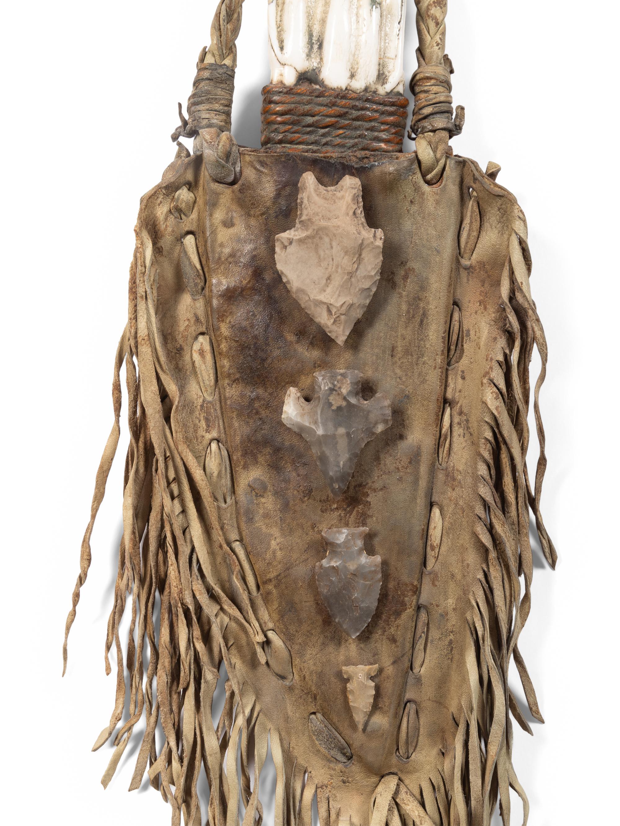 A Fringed Leather or Hide Bag with Attached Arrowheads