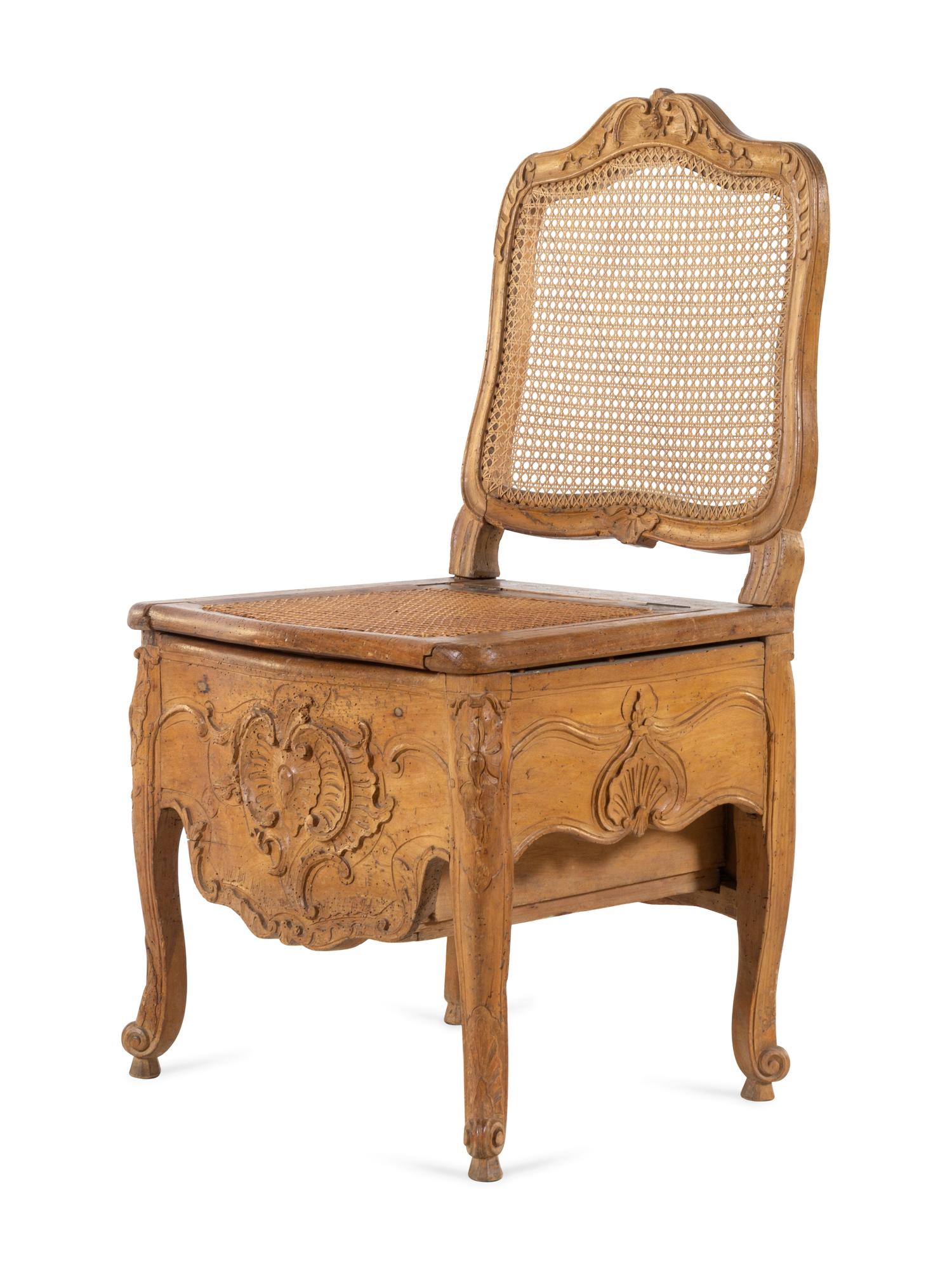 A Louis XV Provincial Carved Fruitwood Commode Chair