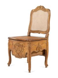 A Louis XV Provincial Carved Fruitwood Commode Chair