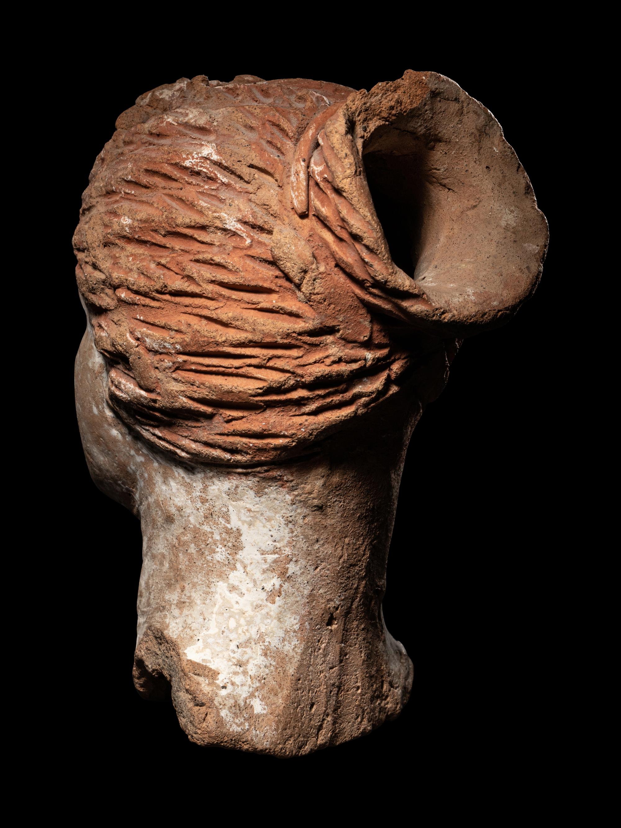 A Greek Terracotta Female Head with a Melon Coiffure