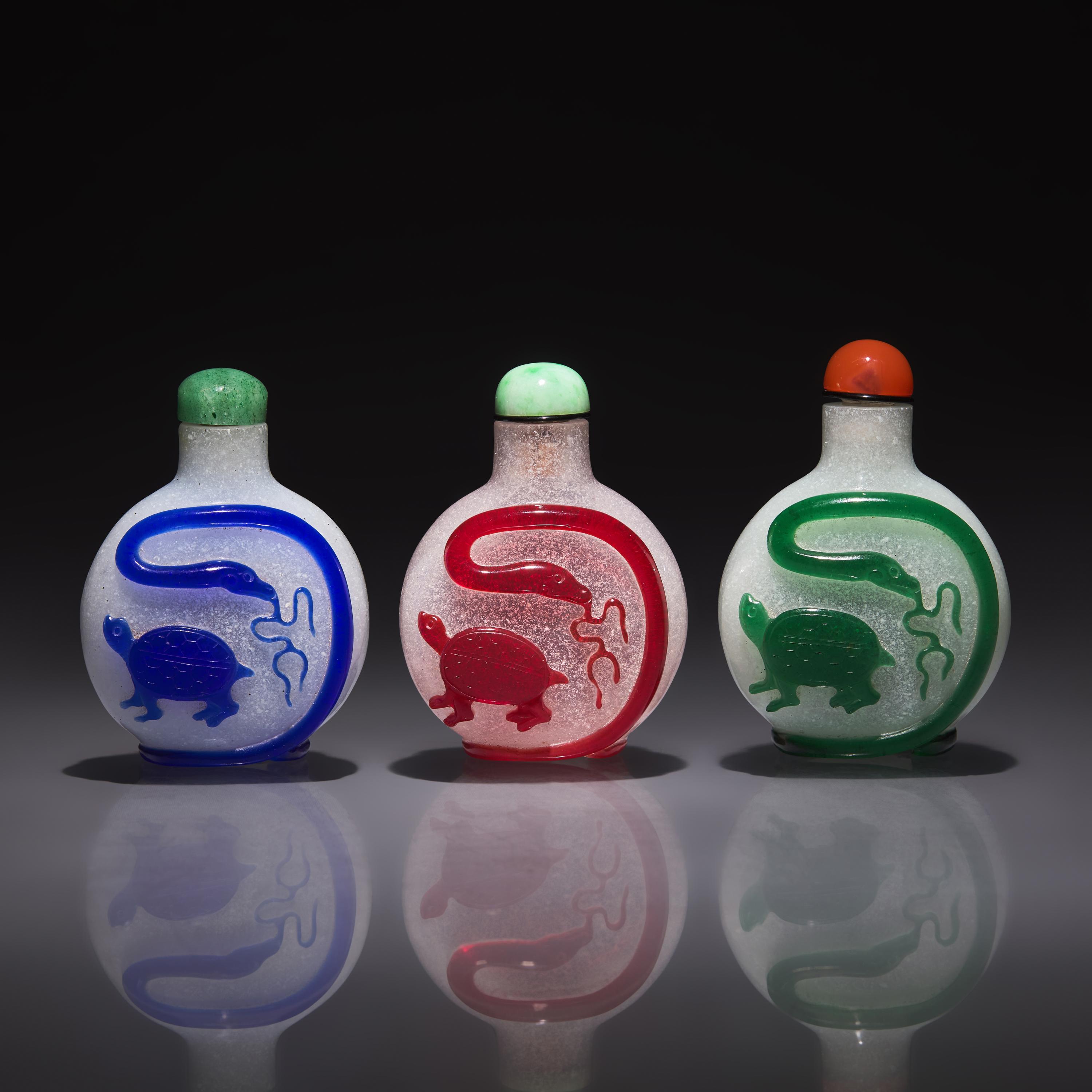Three Chinese Overlay Glass "Xuanwu" Snuff Bottles, Qing Dynasty, 18th/19th Century — 清中晚期 雪霏地套料鼻煙壺三支