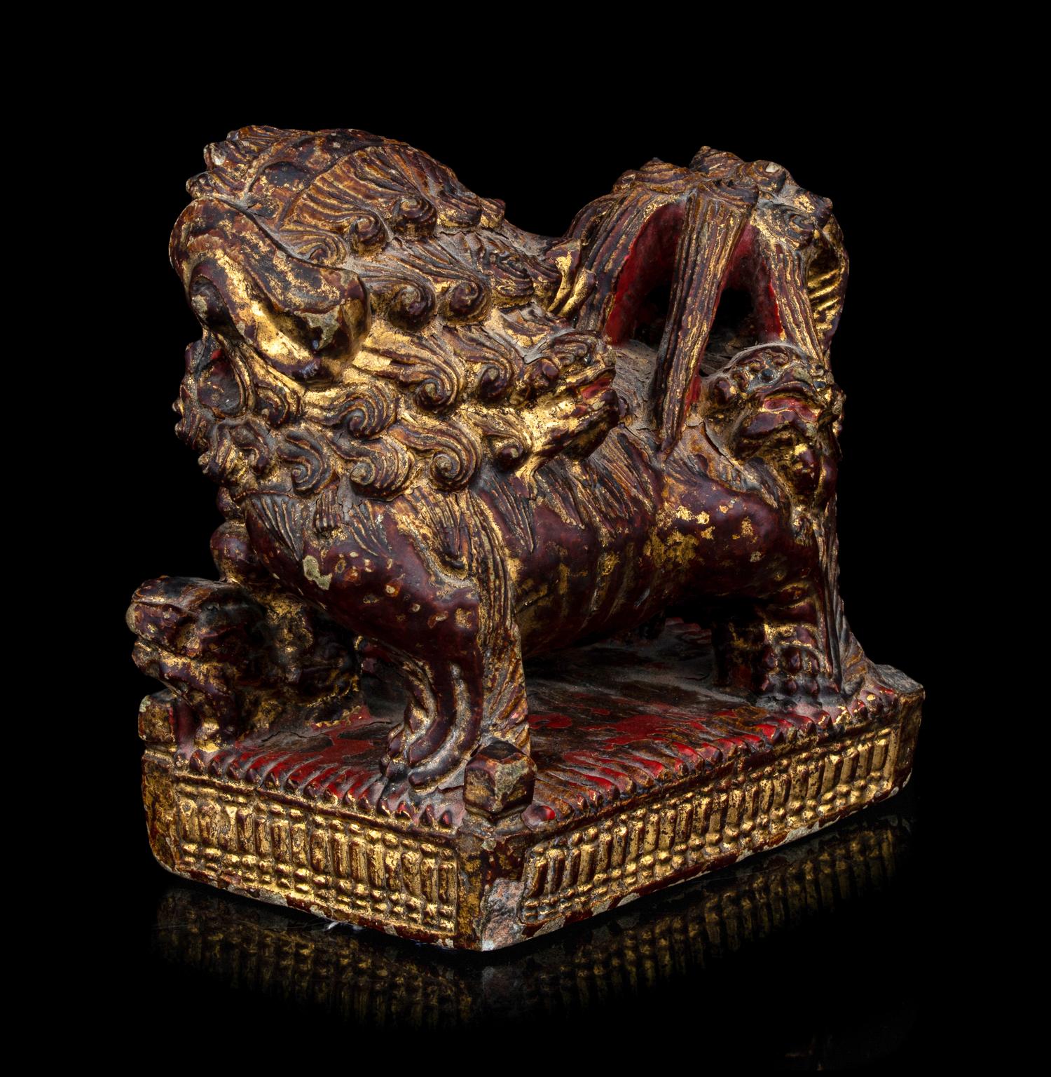 A Chinese Gilt and Red Painted Stone Fu Lion