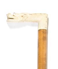 A Chinese Carved Ivory Cane Handle, Height overall 34 x width of handle 3 7/8 inches.