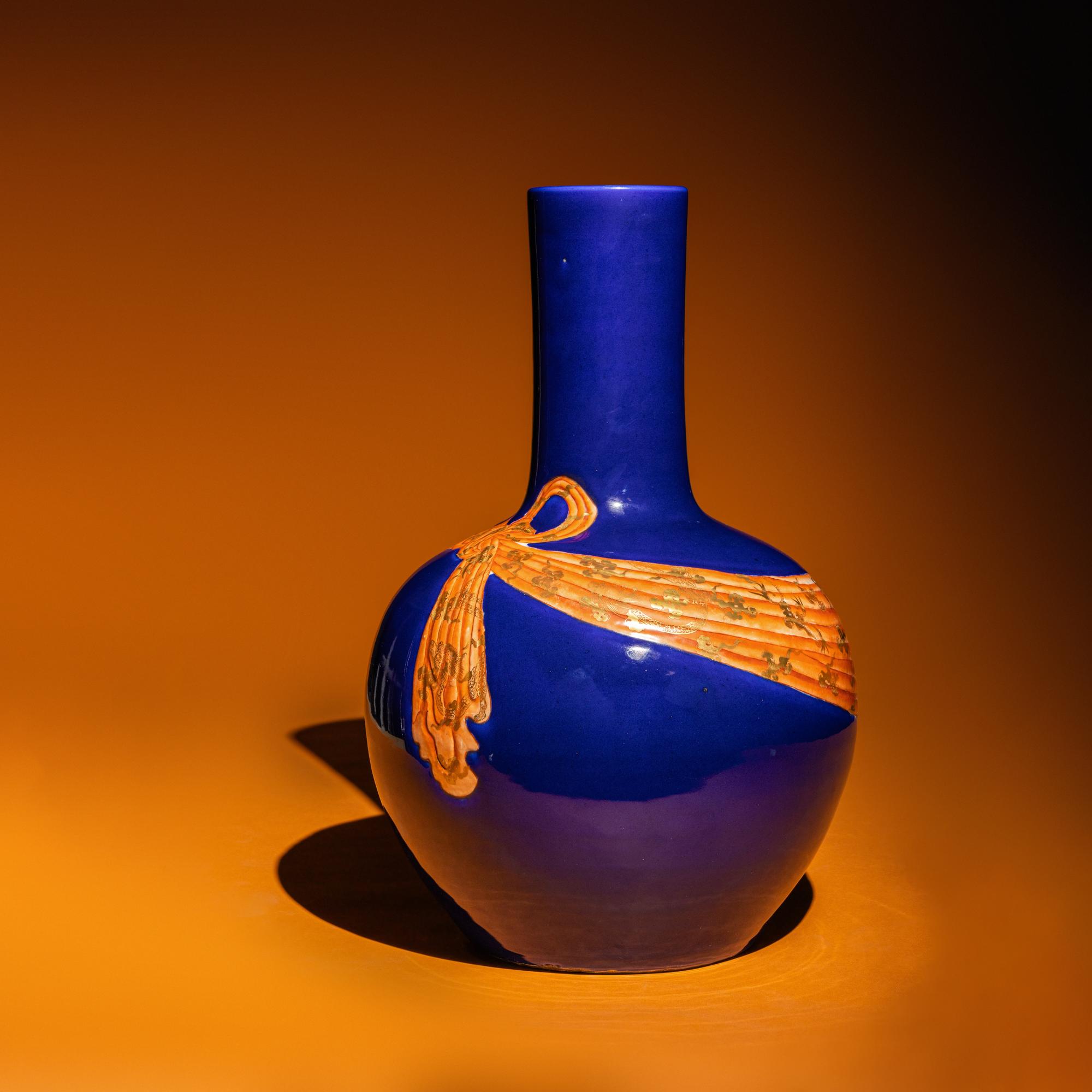 A Large Chinese Gilt and Iron Red Highlighted Blue Glazed Porcelain 'Ribbon-Tied' Vase, Tianqiuping, Late Qing Dynasty/Early Republic Period 晚清/民國 藍地描金包袱式天球瓶
