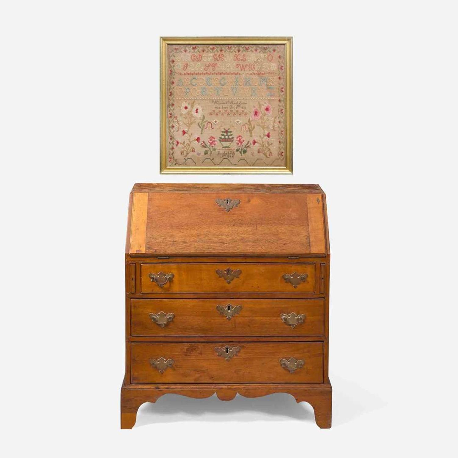 A Federal child's cherry slant-front desk together with a needlework sampler late 18th / early 19th century