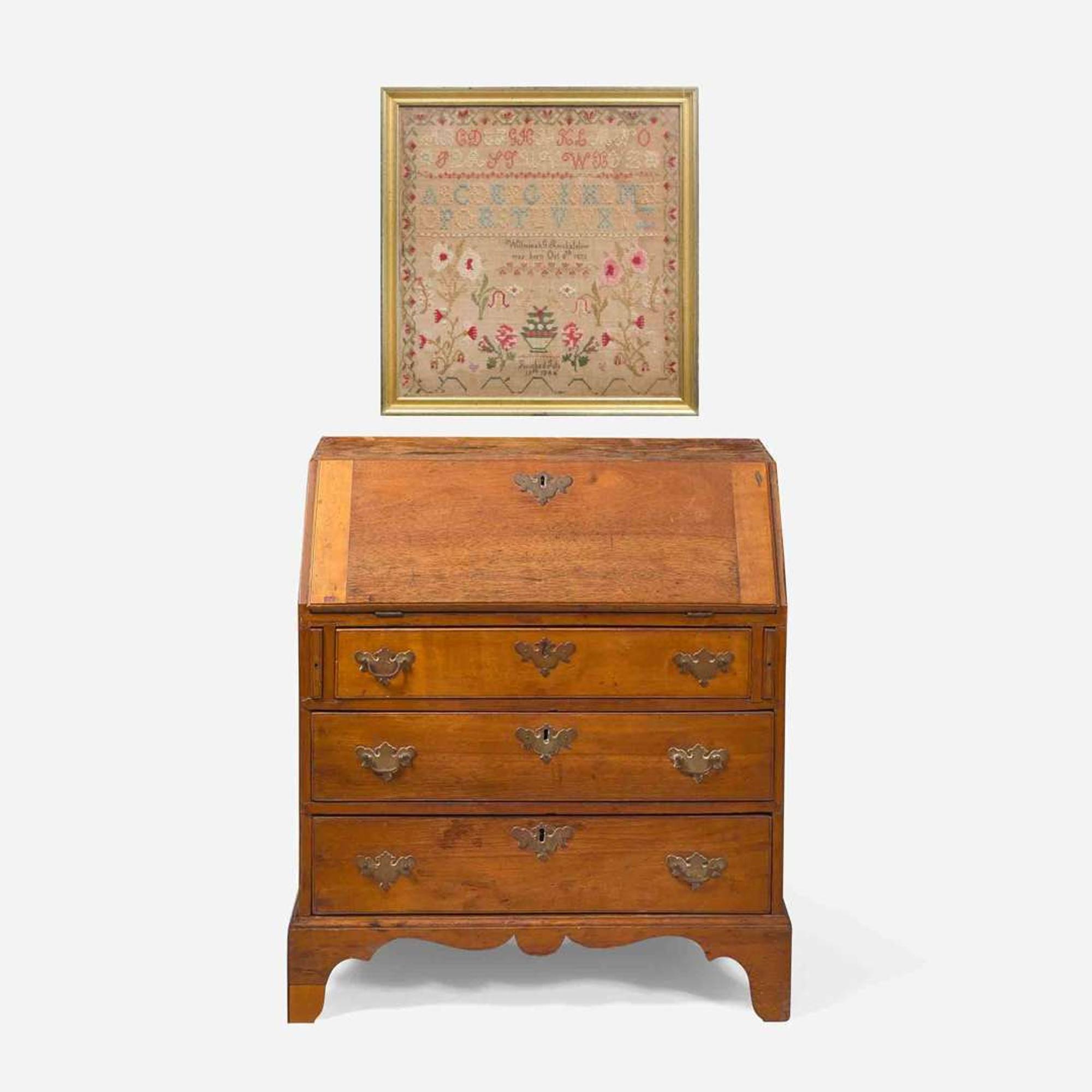 A Federal child's cherry slant-front desk together with a needlework sampler late 18th / early 19th century