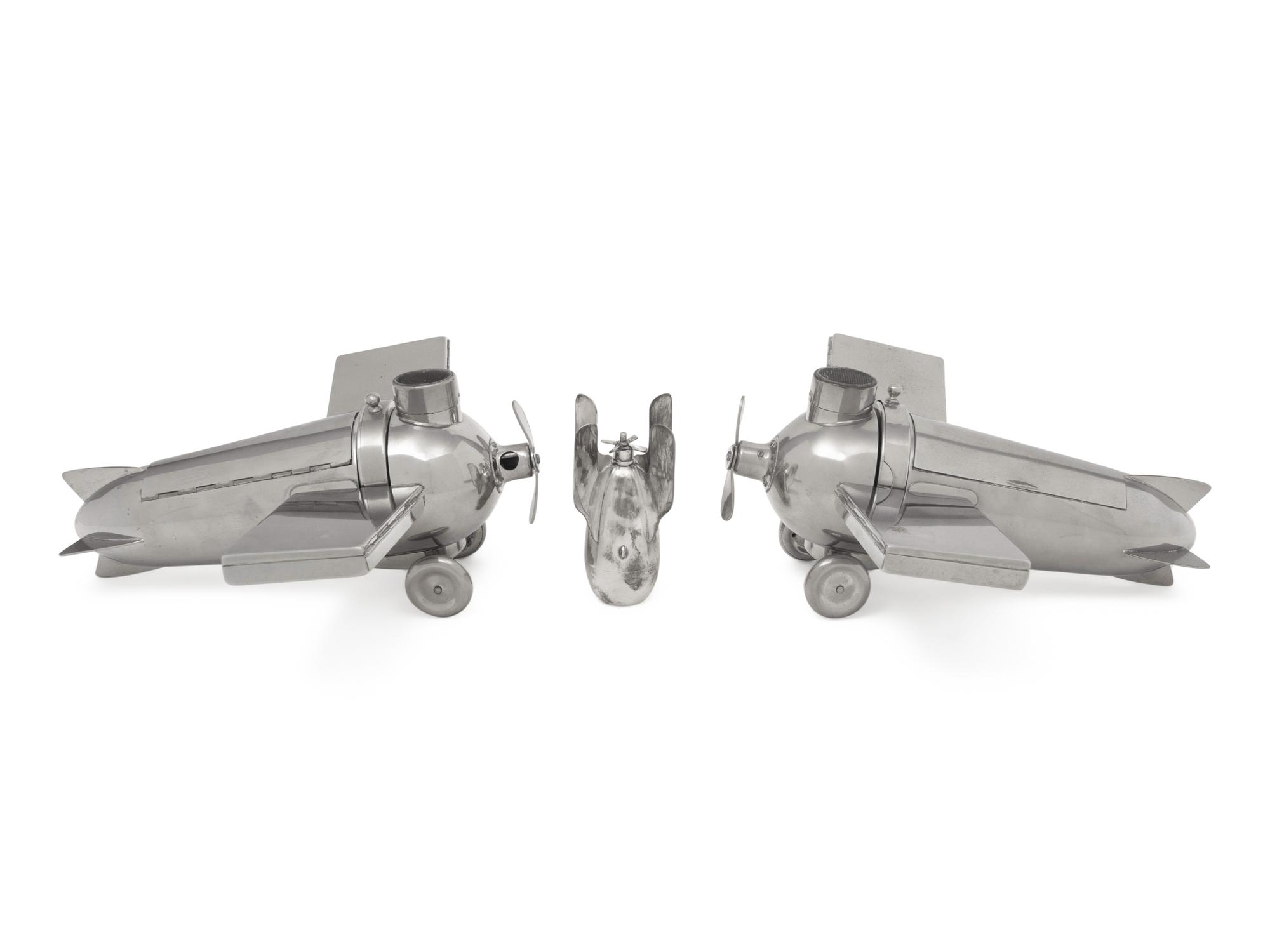 A Pair of German Chromed-Metal Airplane-Form Smoking Sets