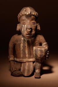 A Nayarit Terracotta Crouching Figure with Vessel