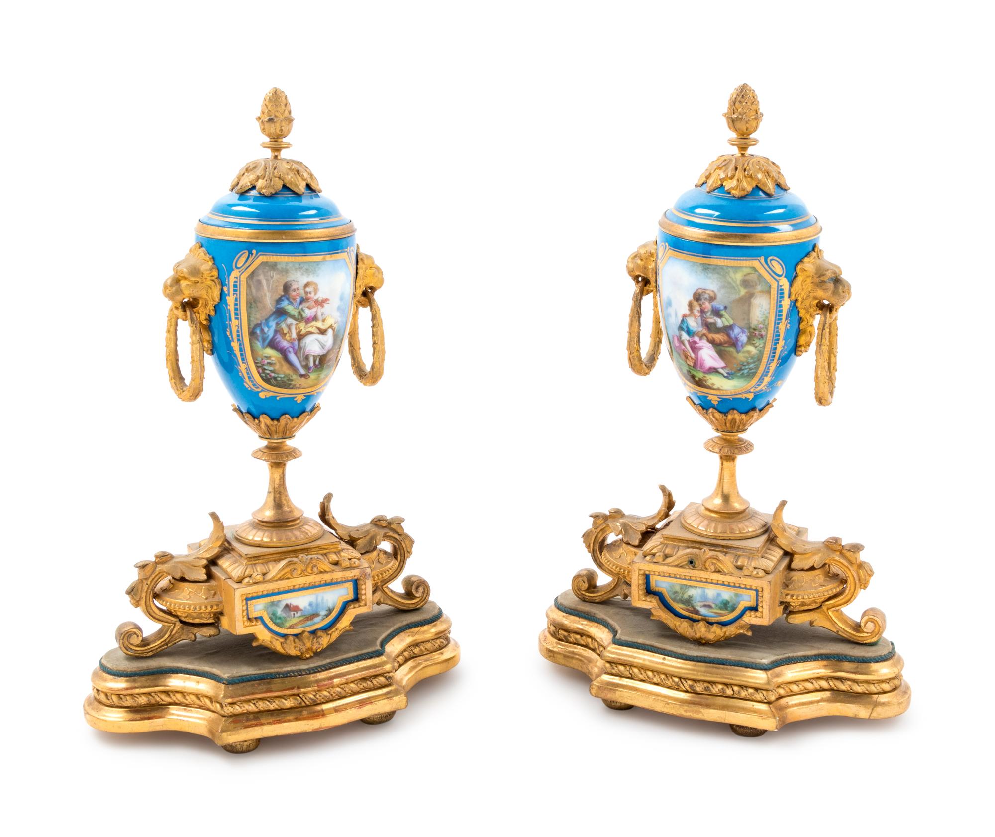 A Pair of Sèvres Style Gilt Bronze Mounted Painted and Parcel Gilt Porcelain Urns