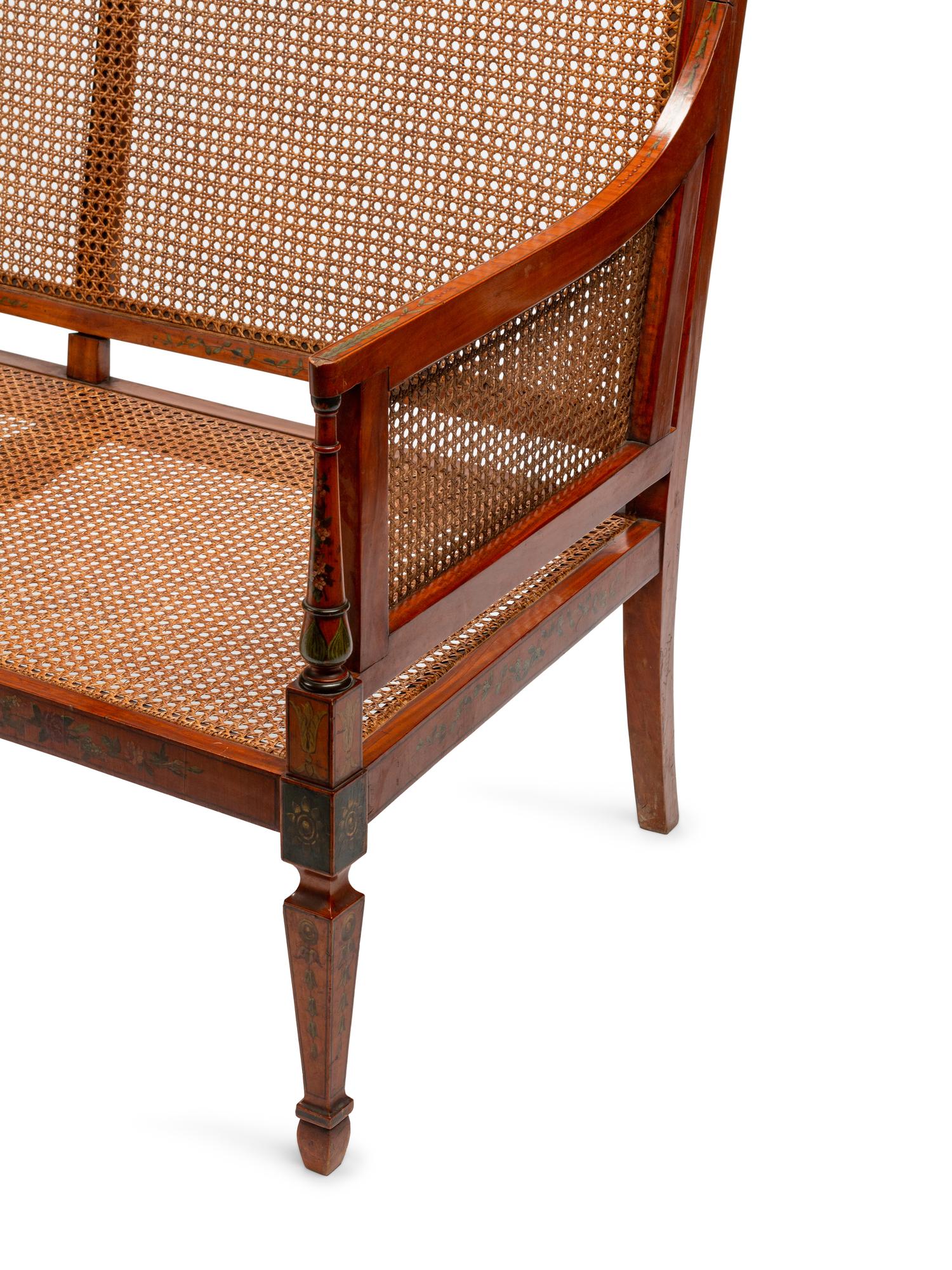 An Edwardian Painted Satinwood Caned Settee