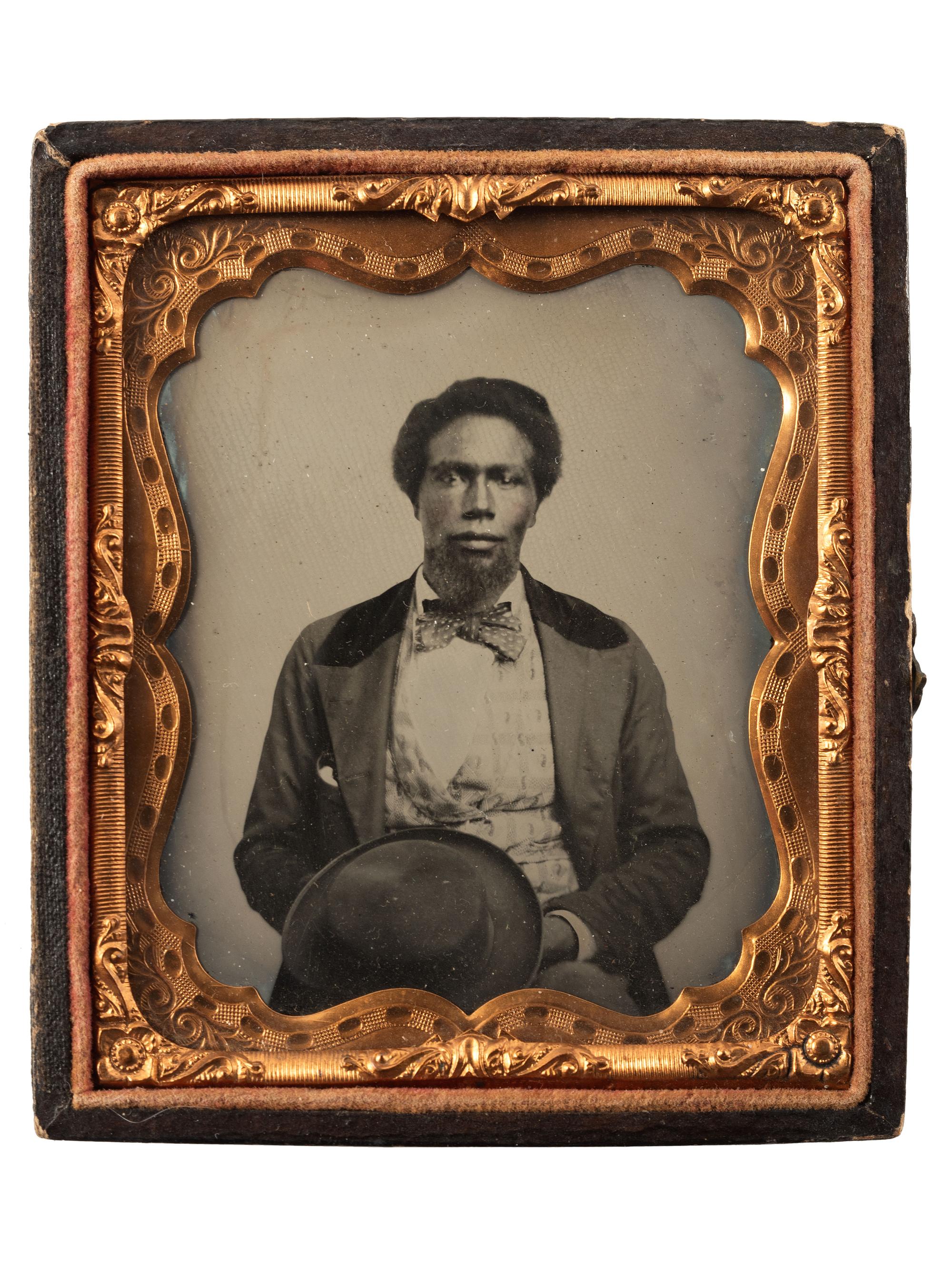 [EARLY PHOTOGRAPHY]. Sixth plate ruby ambrotype of a young African American male subject.