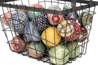A Collection of English Polychrome Glazed Carpet Balls in a Wirework Basket