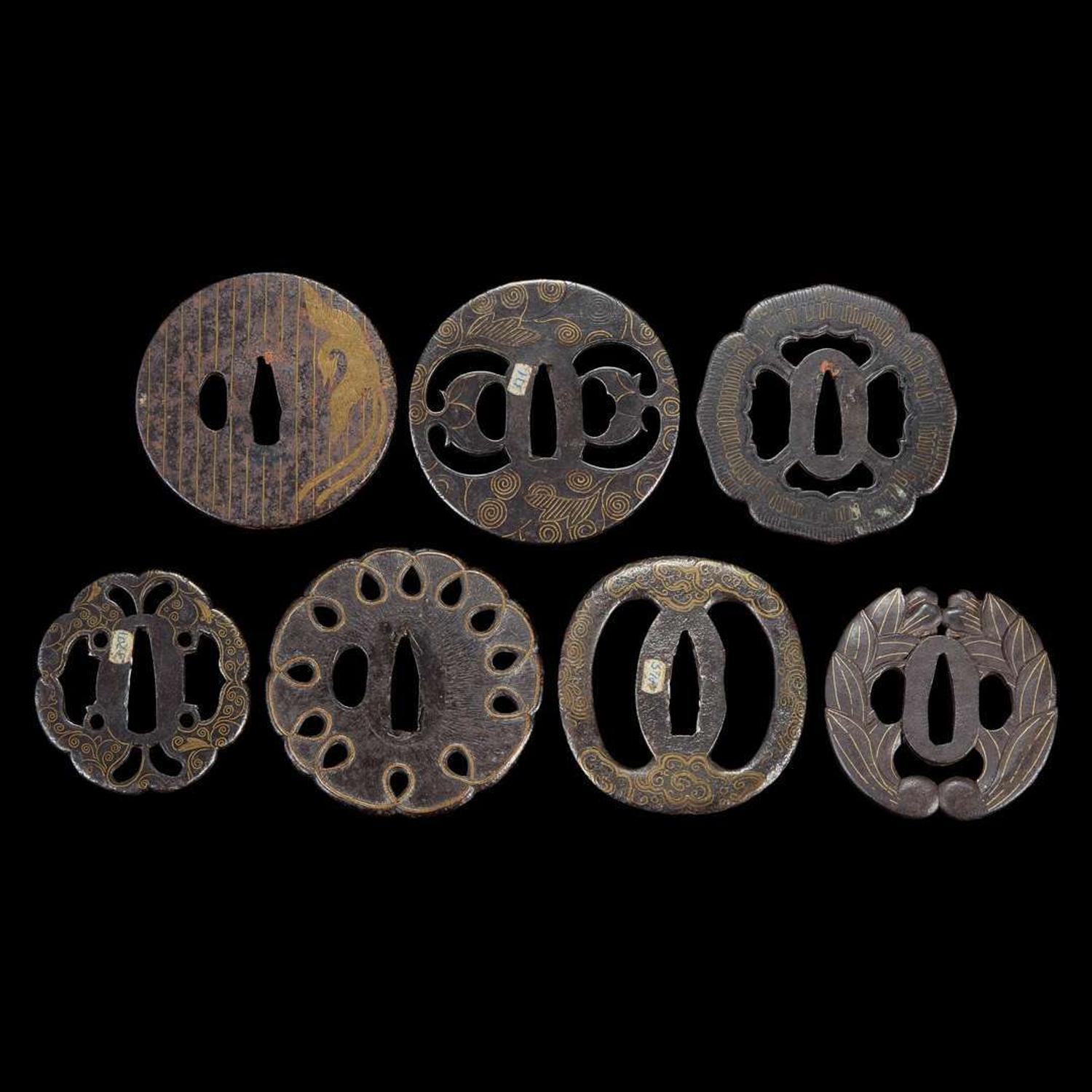 Group of seven Japanese inlaid iron tsuba Edo period or earlier