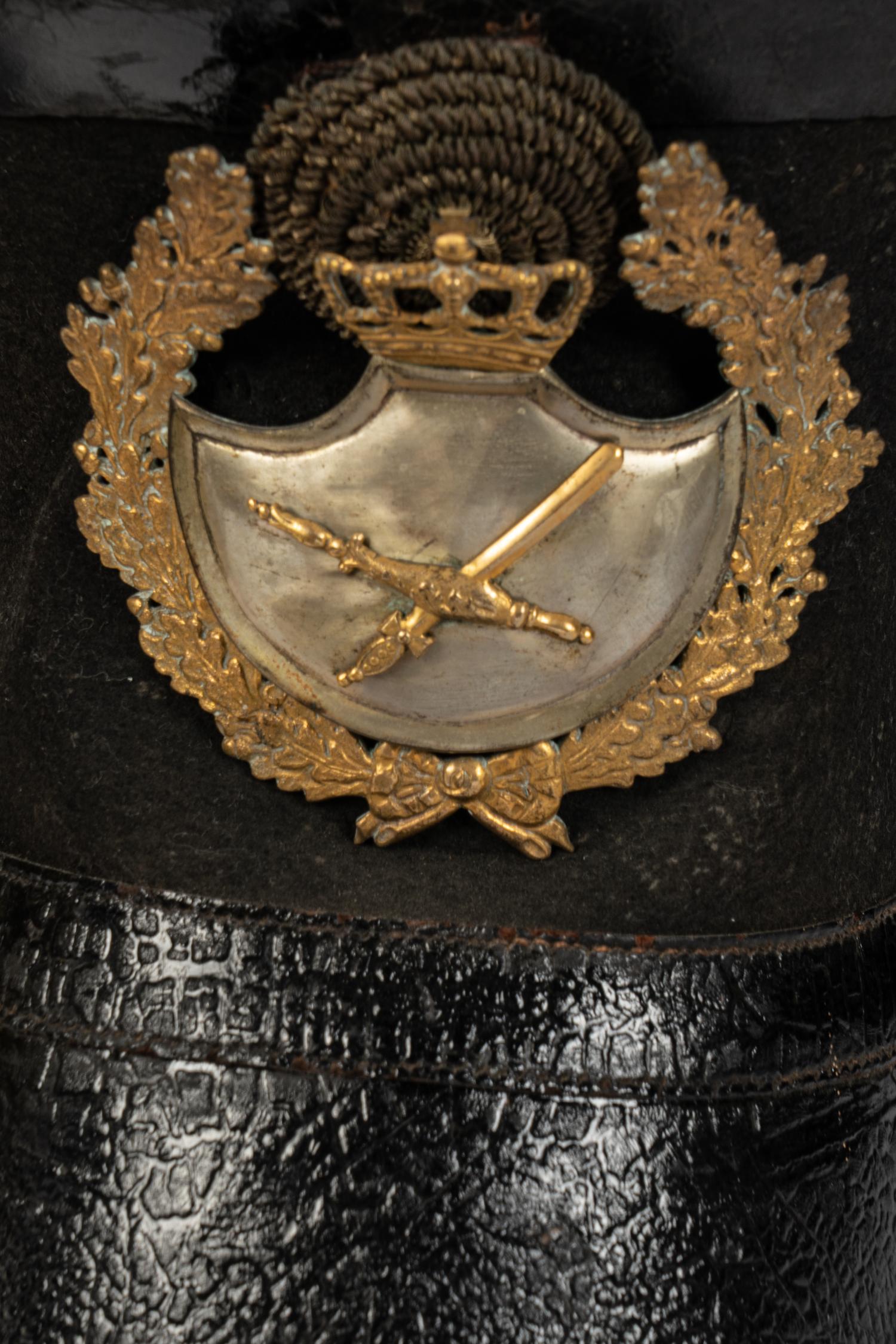 A Collection of Twenty-One Military Parade Helmets, Hats and Masks