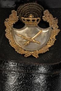 A Collection of Twenty-One Military Parade Helmets, Hats and Masks