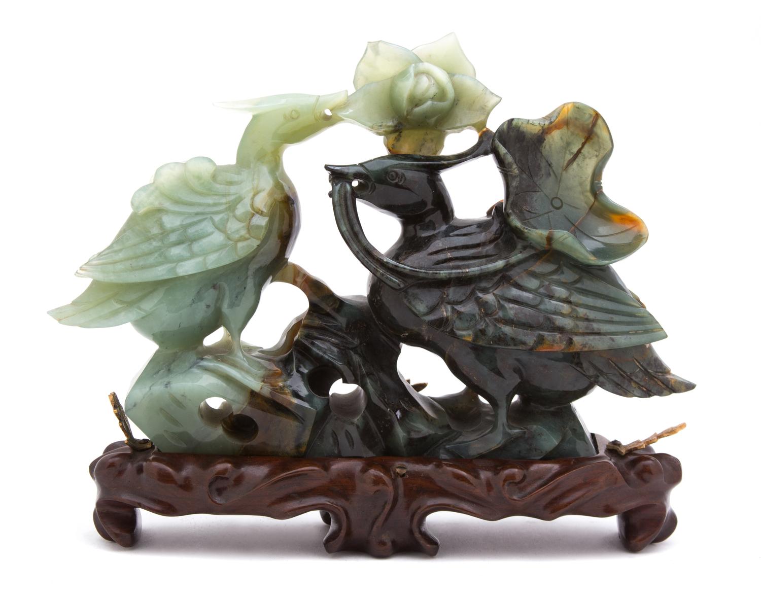 A Chinese Carved Jadeite Model of Two Birds with Lotus Blossom Height 6 1/2 x width 9 1/2 inches. — LATE 19TH/EARLY 20TH CENTURY