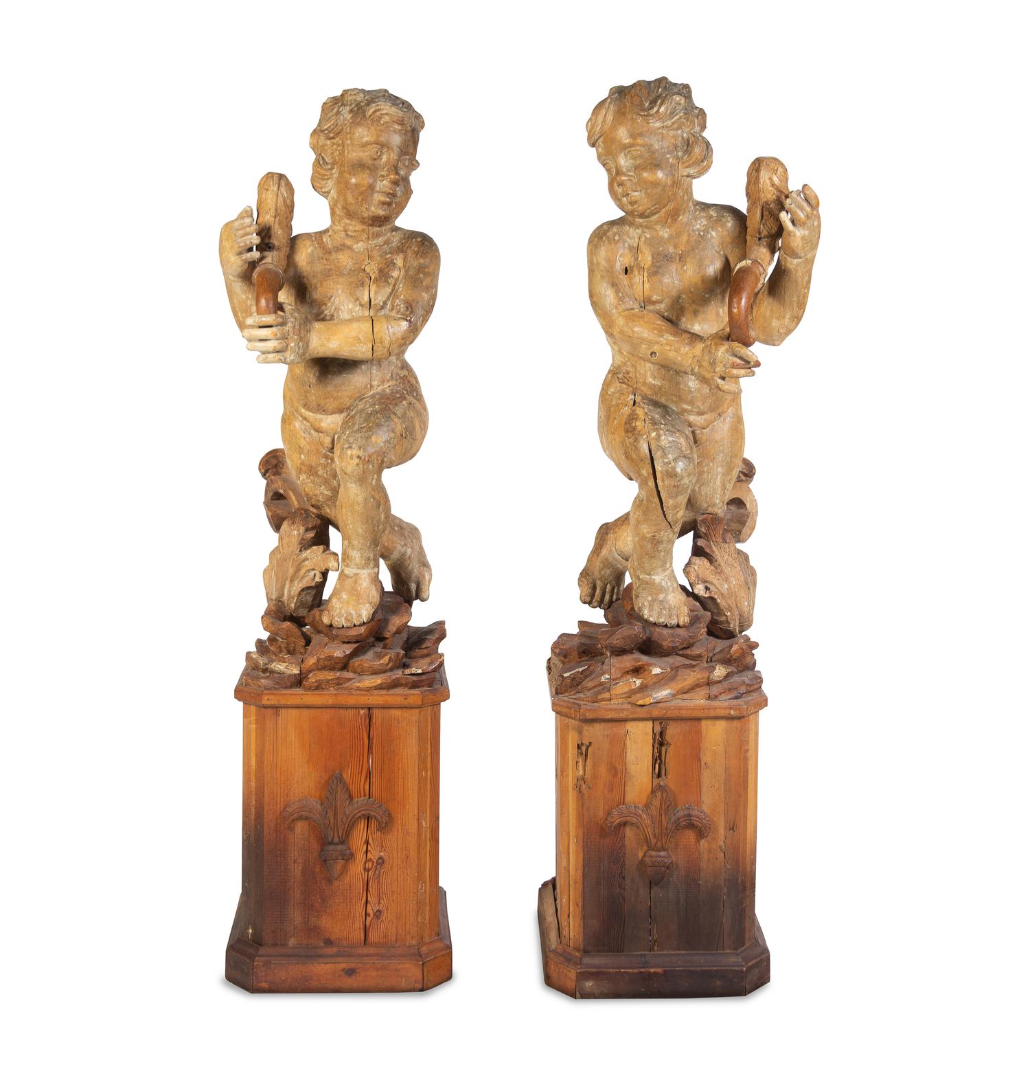 A Pair of Florentine Carved Walnut Figures of Putti on Plinths