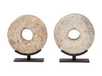 Two Millstone Disks on Metal Stands