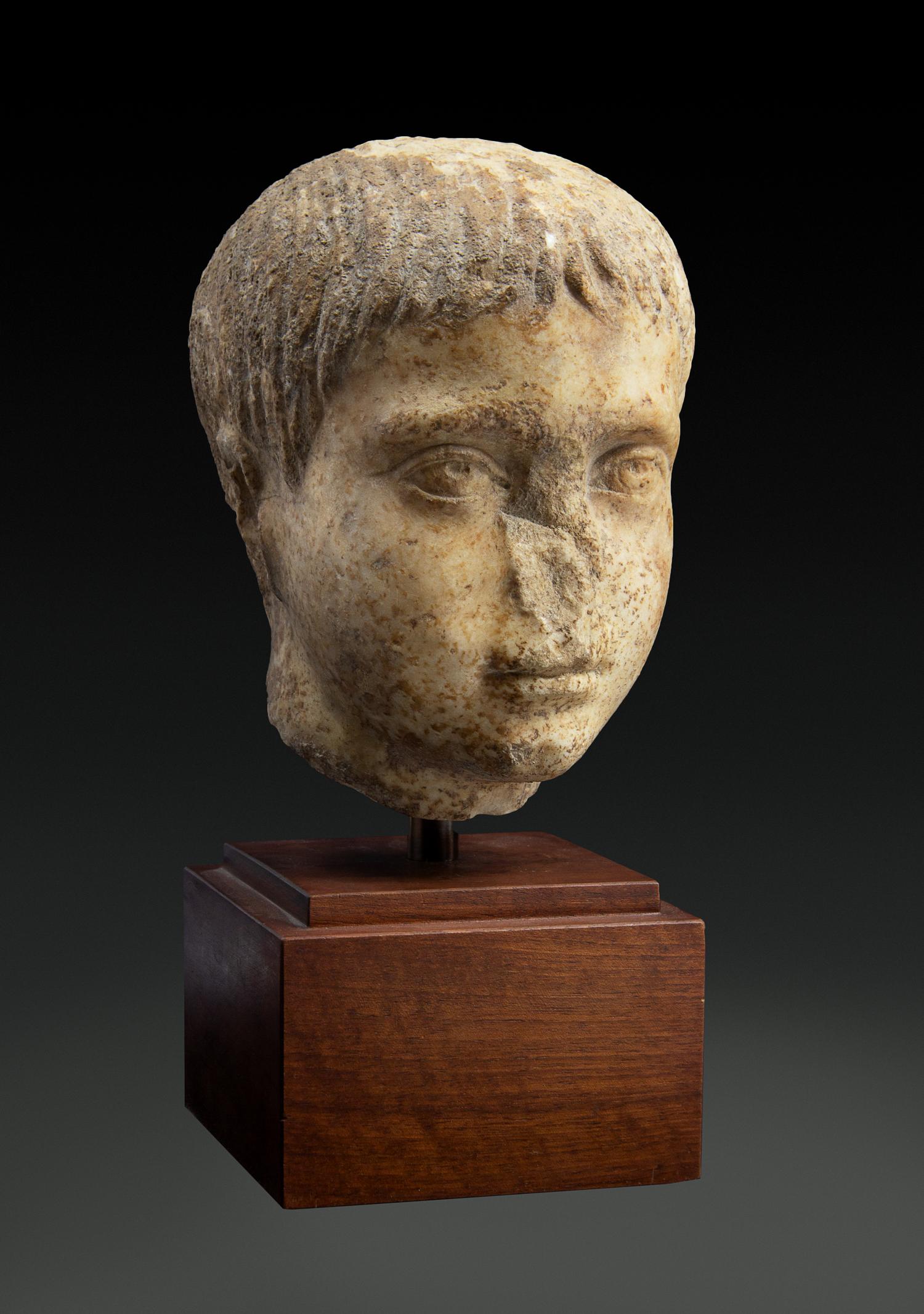 A Roman Marble Head of a Youth Height 8 inches. — CIRCA 2ND CENTURY C.E.
