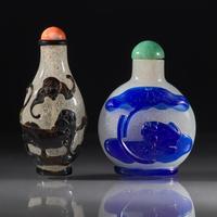 Two Chinese Carved Overlay Glass Snuff Bottles, Qing Dynasty, Circa 1780-1850 — 1780-1850年 雪霏地套黑料及藍料鼻煙壺兩支