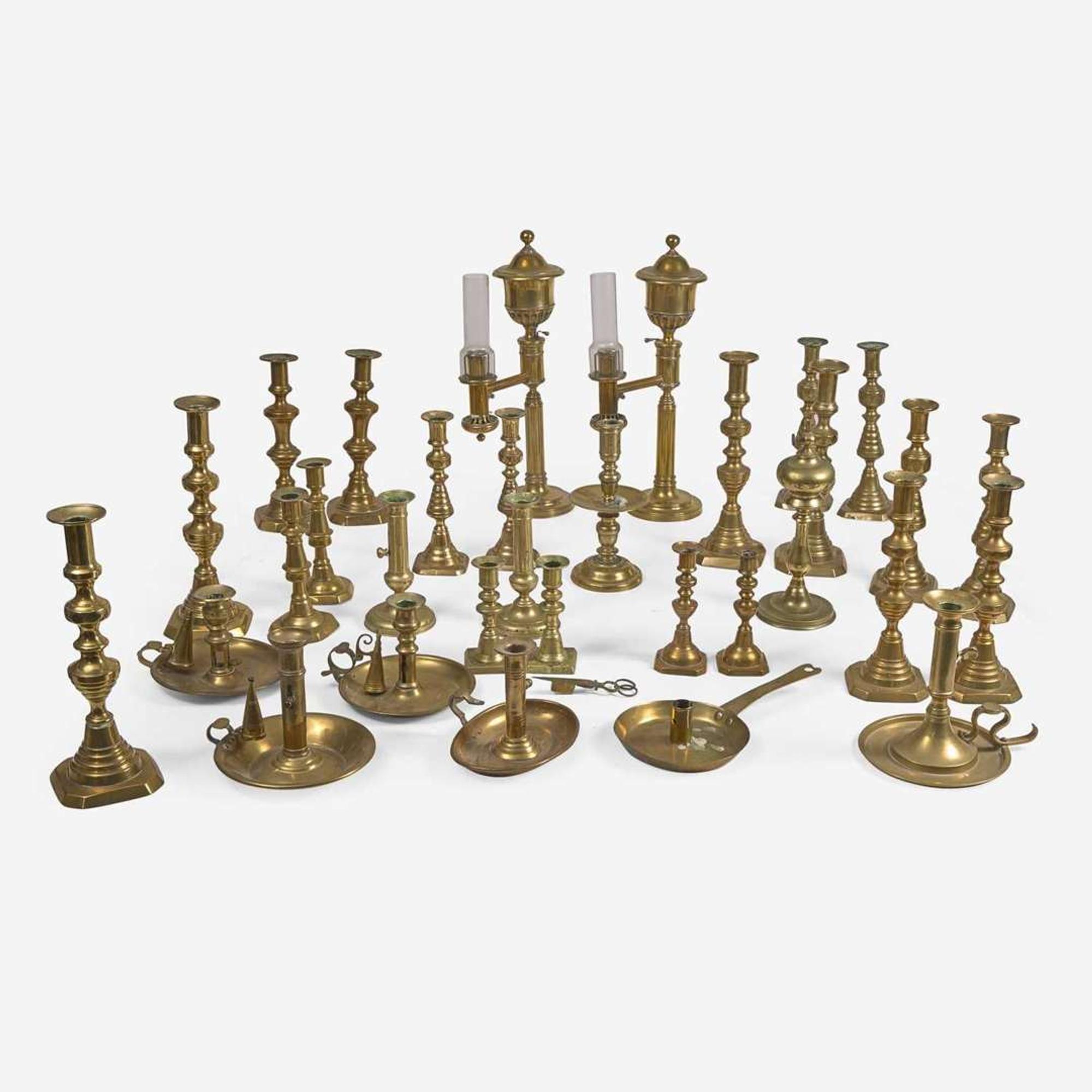 A collection of twenty-one brass candlesticks and lamps Predominately 18th / 19th century