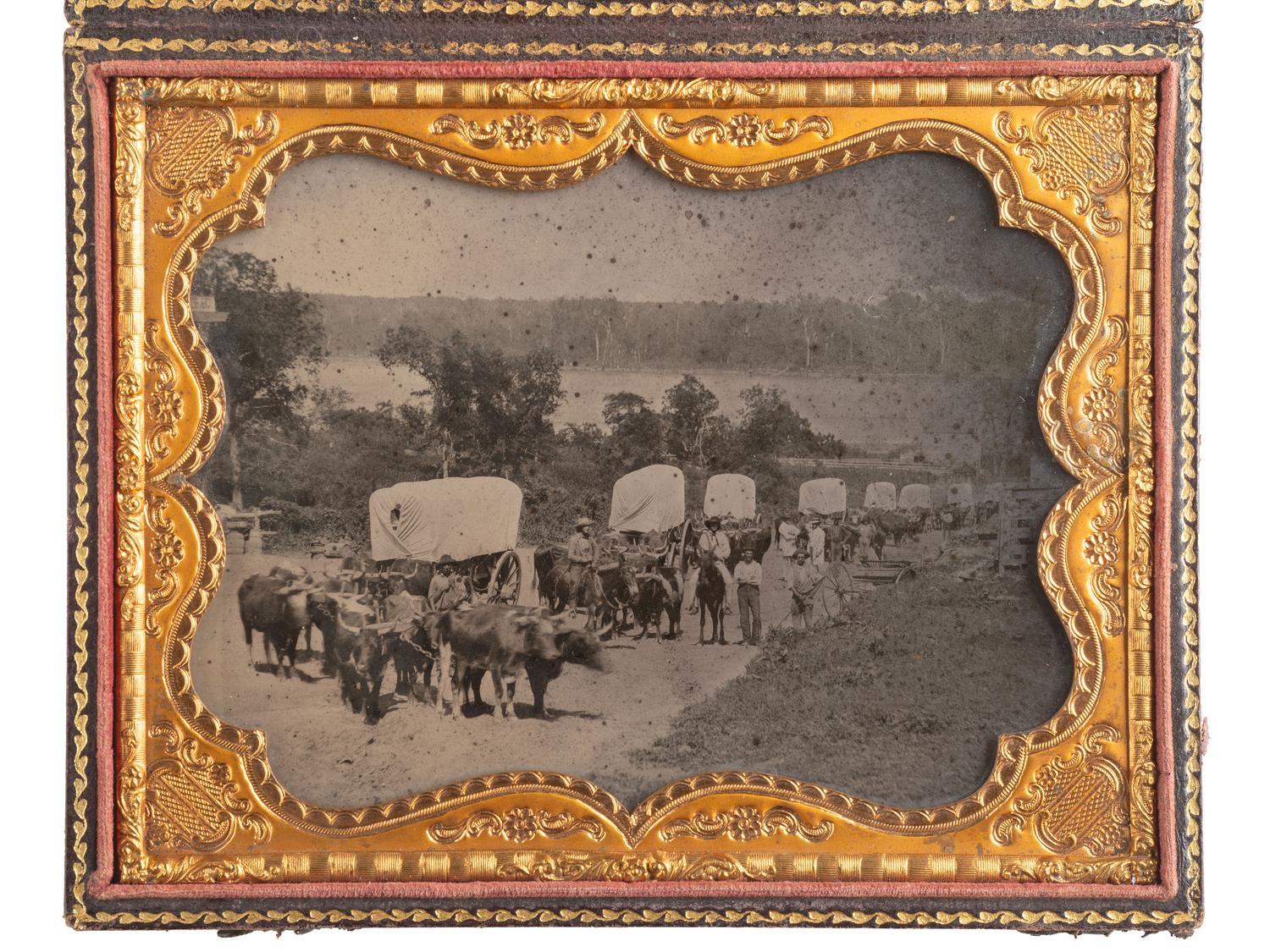 [EARLY PHOTOGRAPHY]. Ambrotype of seven ox-drawn wagons on a road, possibly in Nebraska City, NE. Ca 1859.