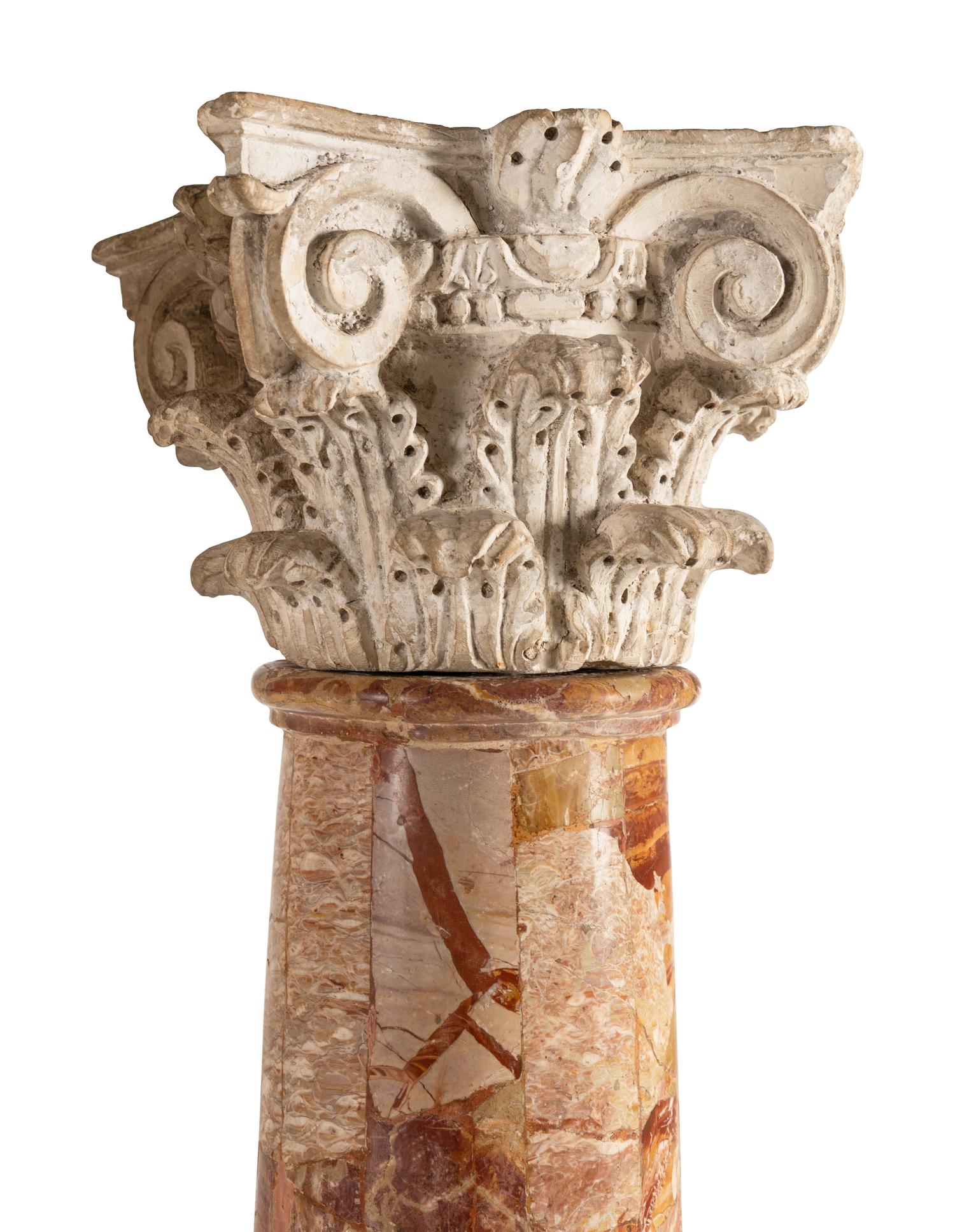 A Pair of Carved Limestone Capitals with Breccia Marble Columns
