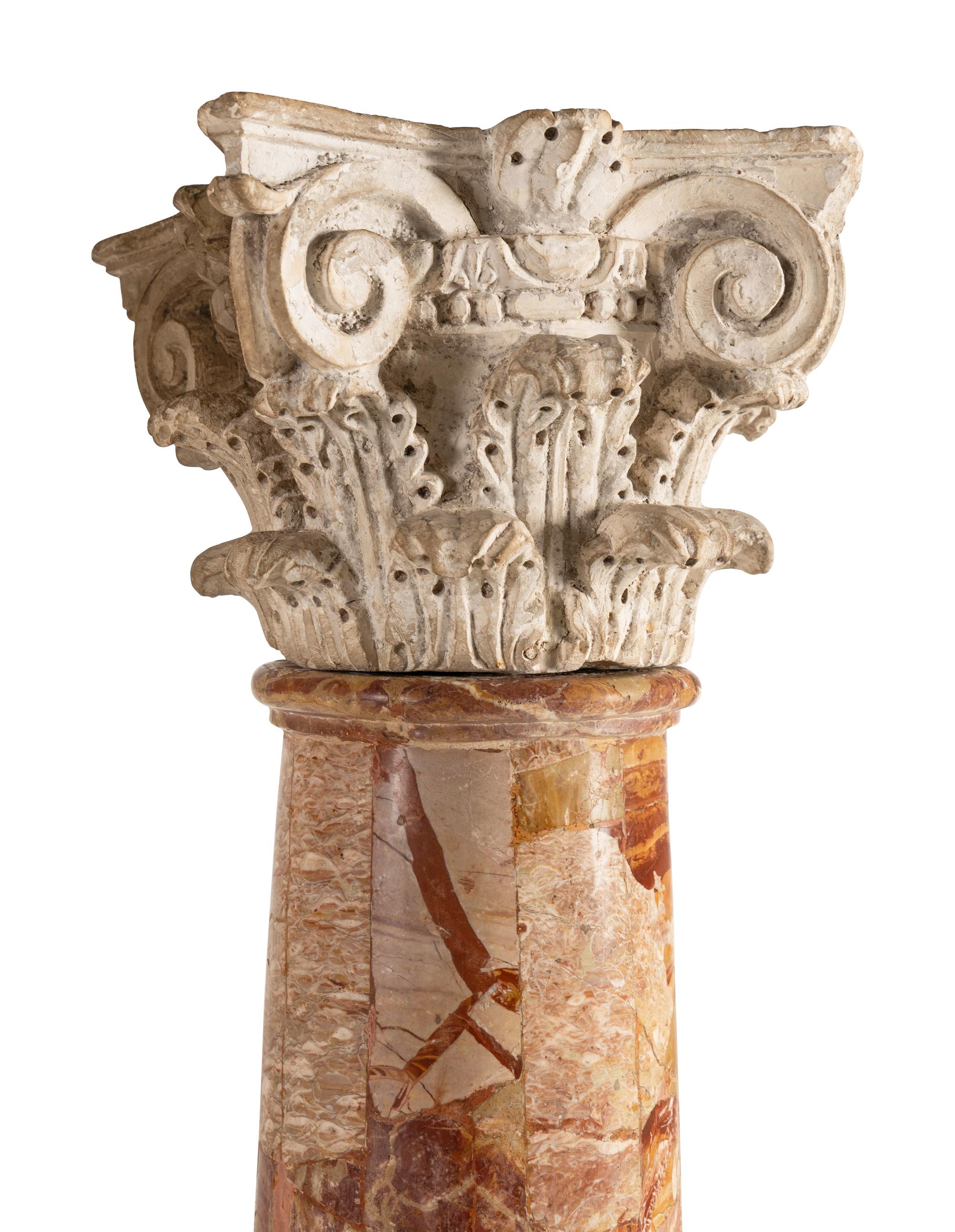 A Pair of Carved Limestone Capitals with Breccia Marble Columns