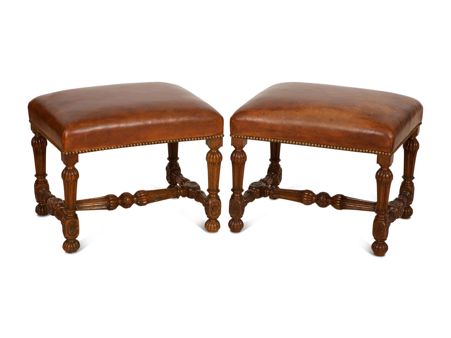 A Pair of Carved Walnut Regence Style Leather Upholstered Stools