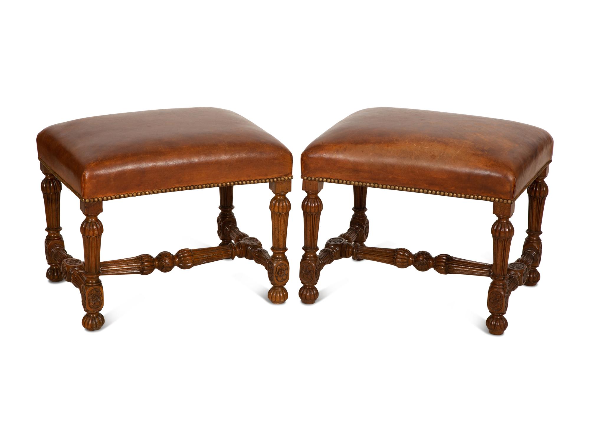 A Pair of Carved Walnut Regence Style Leather Upholstered Stools