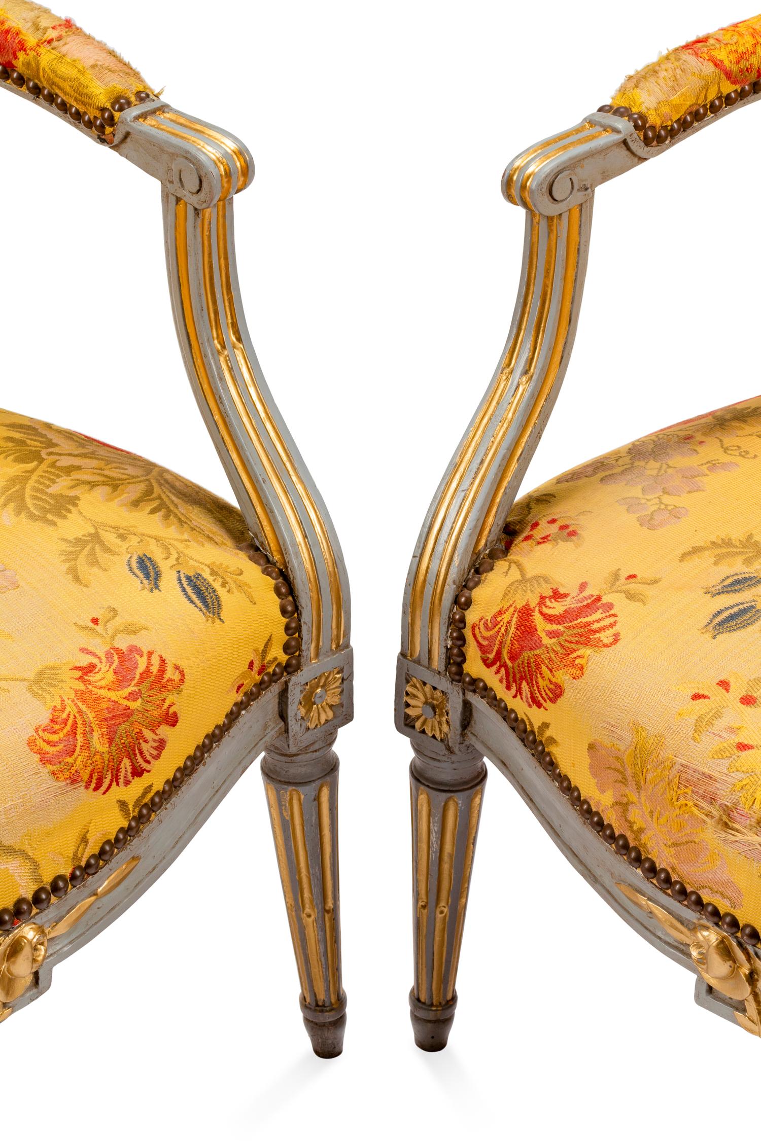 A Pair of Louis XVI Painted and Parcel Gilt Fauteuils