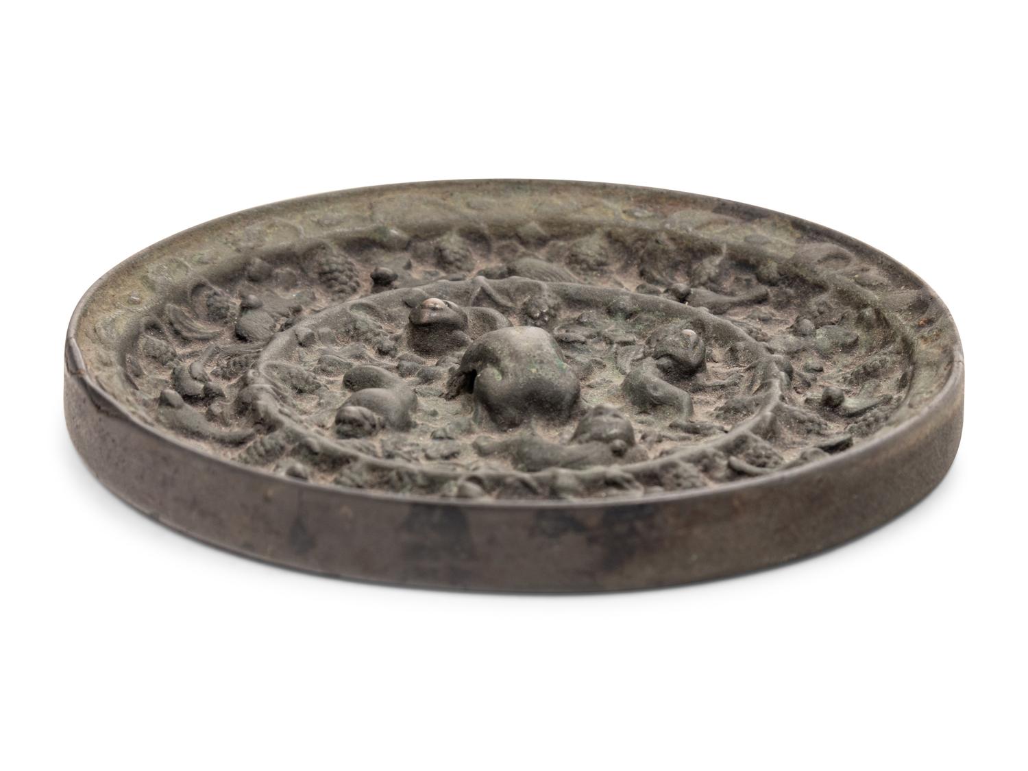A Chinese Bronze Circular 'Mythical Beasts and Grapes' Mirror