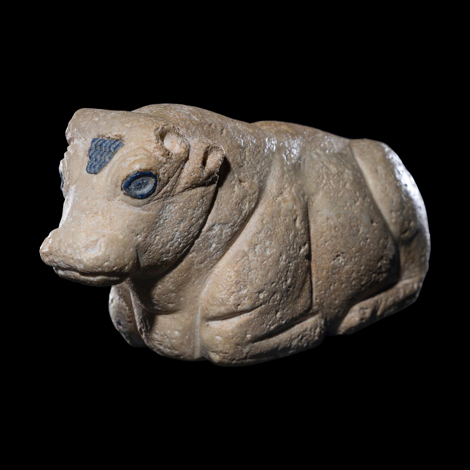A Mesopotamian Limestone Recumbent Bull with Lapis Lazuli Inlays