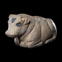 A Mesopotamian Limestone Recumbent Bull with Lapis Lazuli Inlays