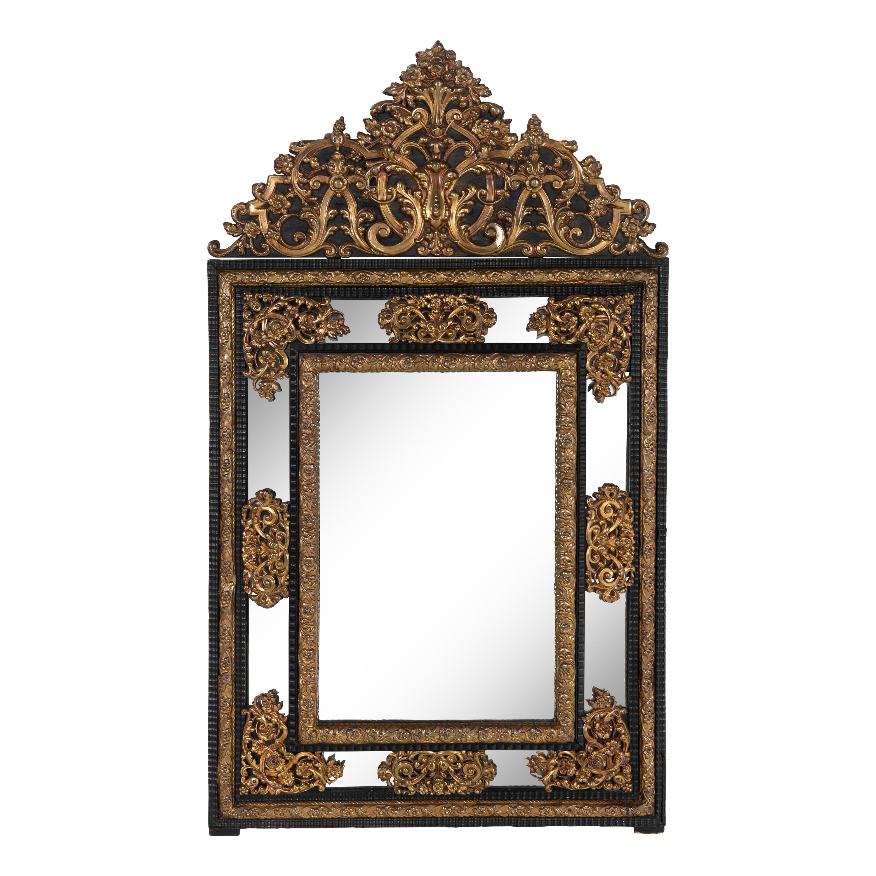 A Baroque Style Gilt Metal Mounted Ebonized Mirror