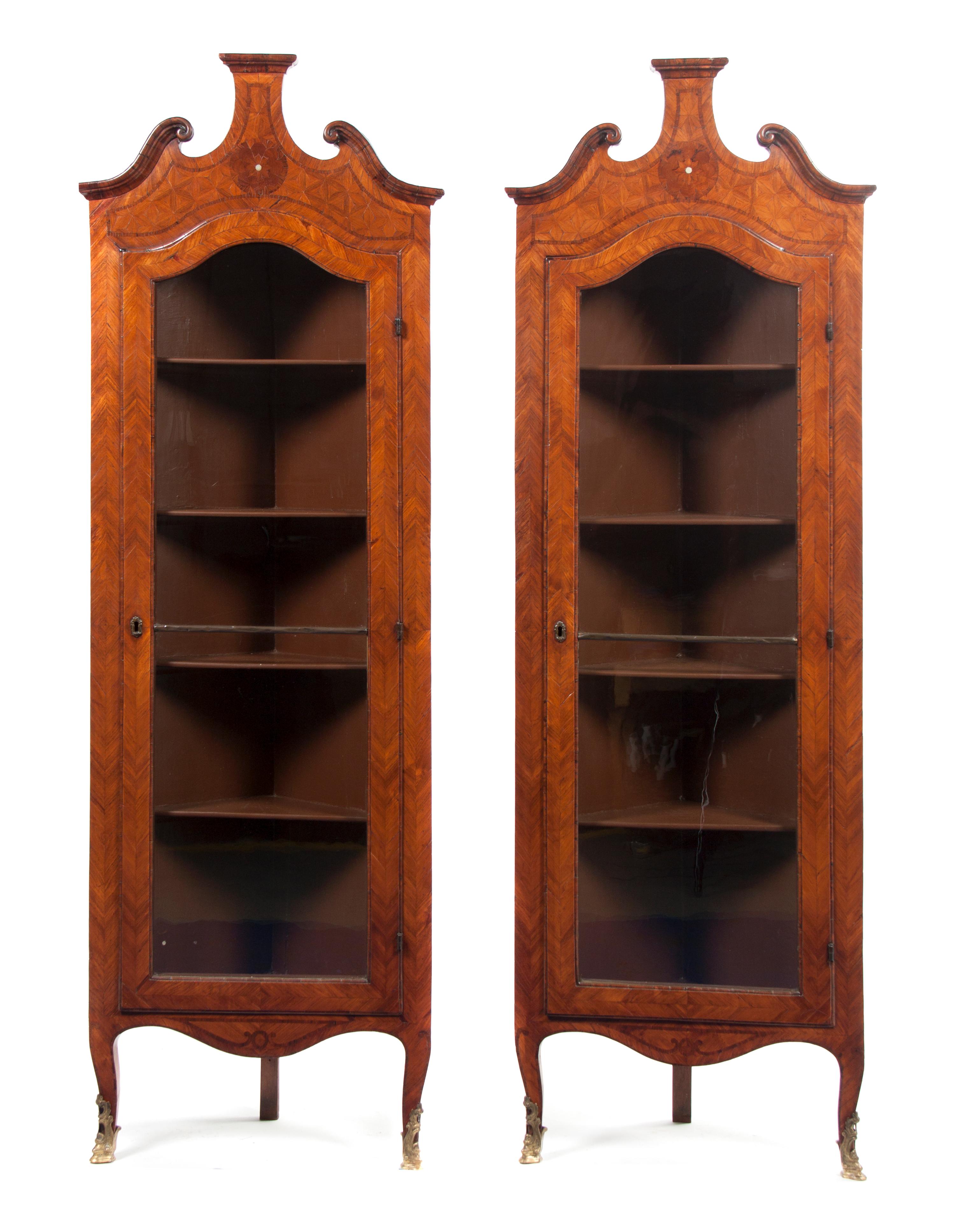 A Pair of Continental Parquetry Corner Cabinets, Height 75 1/2 x width 24 7/8 x depth 13 1/8 inches.