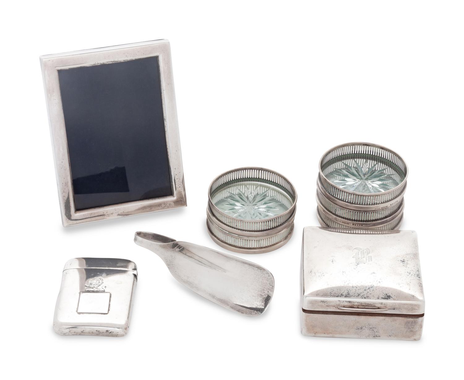 comprising a picture frame, five silver and glass coasters, a trinket box with wooden interior, a cigarette case, and a shoe horn, 9 items total.