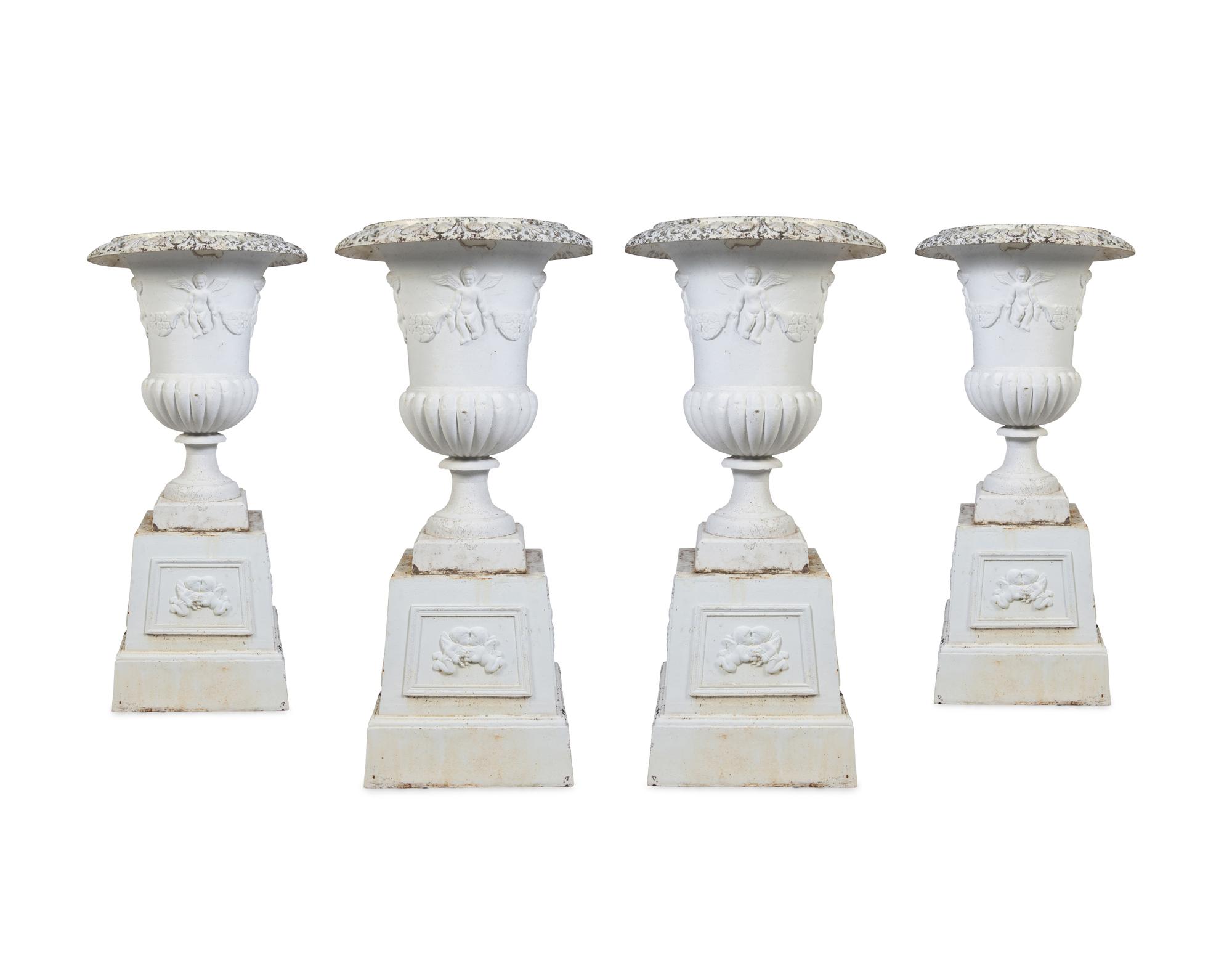 A Set of Four Victorian Style Painted Cast Iron Urns and Plinths