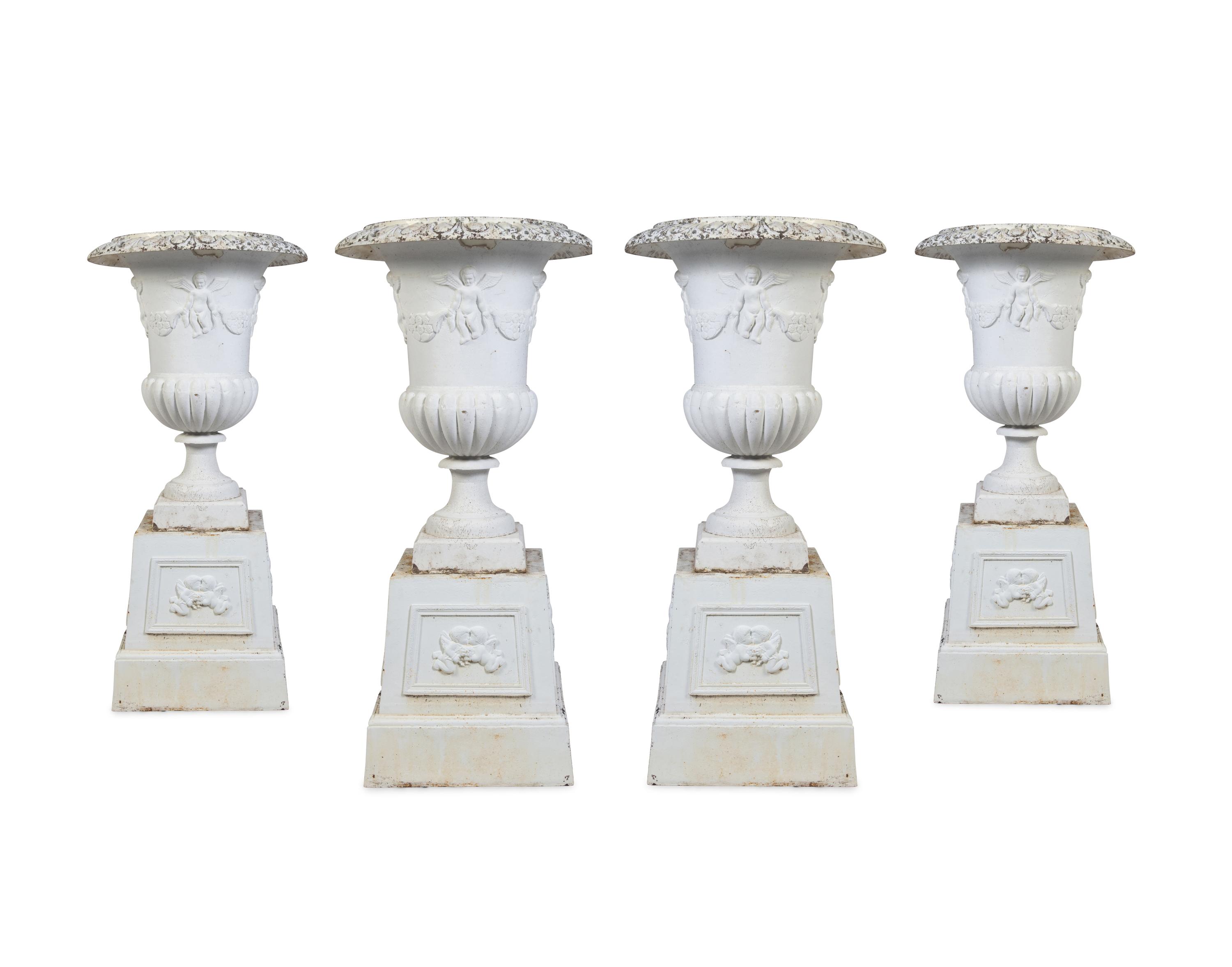 A Set of Four Victorian Style Painted Cast Iron Urns and Plinths