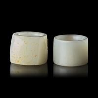 Two Chinese Carved Russet and White Jade Archer's Rings 清 白玉帶沁扳指兩枚
