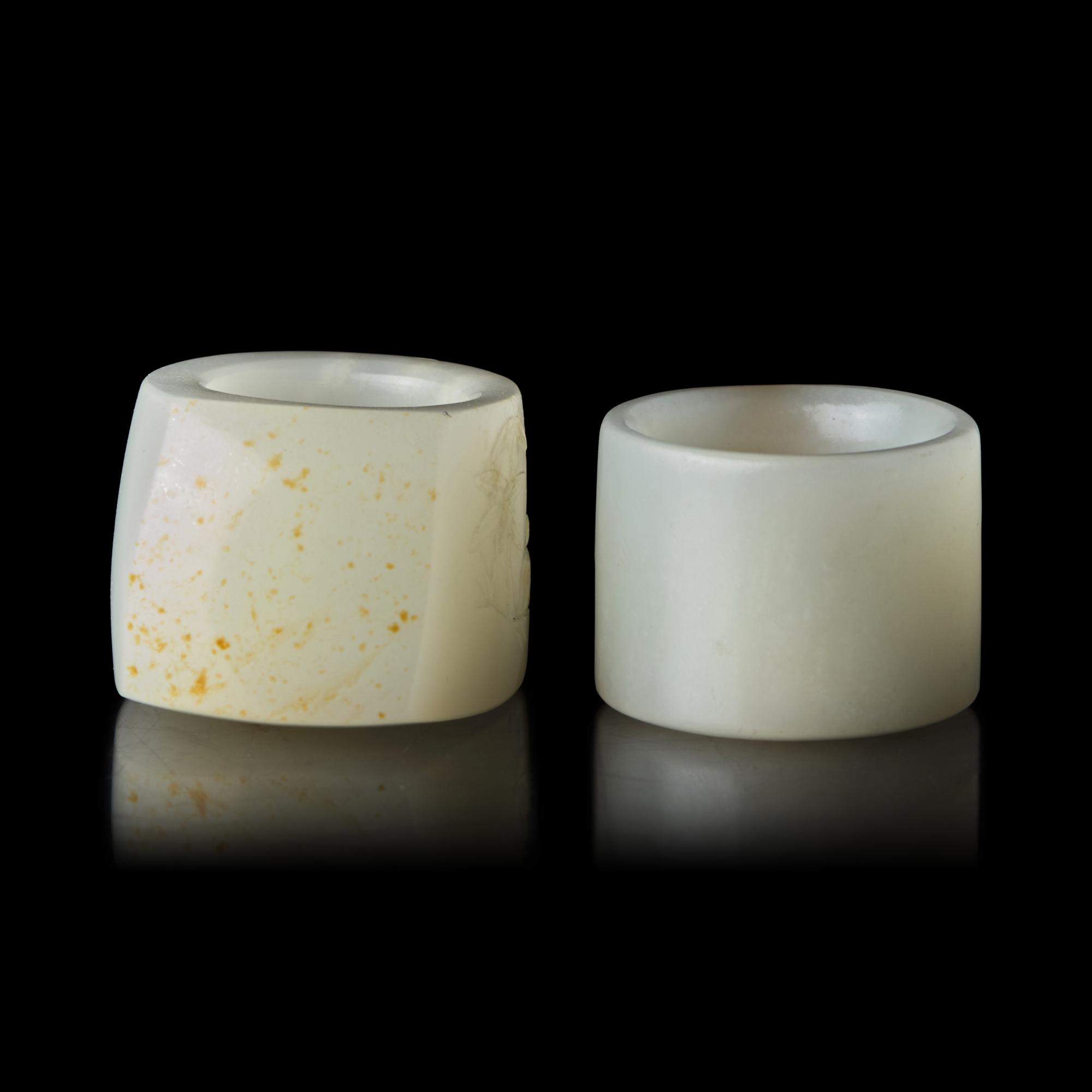 Two Chinese Carved Russet and White Jade Archer's Rings 清 白玉帶沁扳指兩枚
