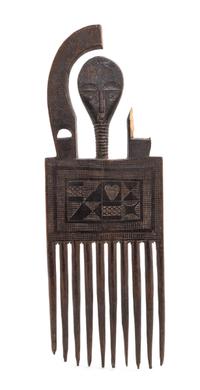 An Ashanti Carved Wood Comb. Height 9 x width 3 1/4 x depth 1/4 inches.