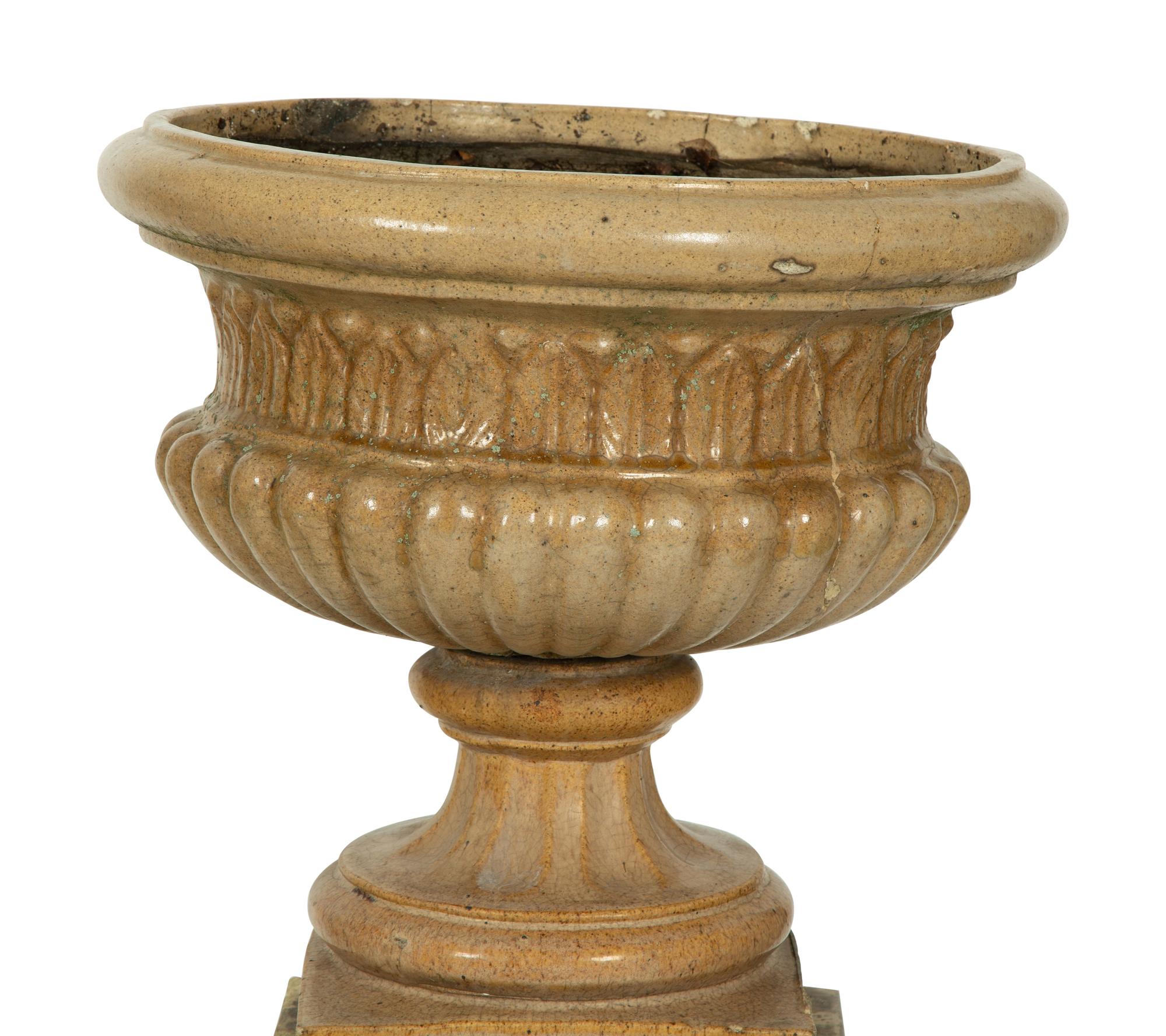 A Pair of Continental Ceramic Urns on Pedestals — EARLY 20TH CENTURY