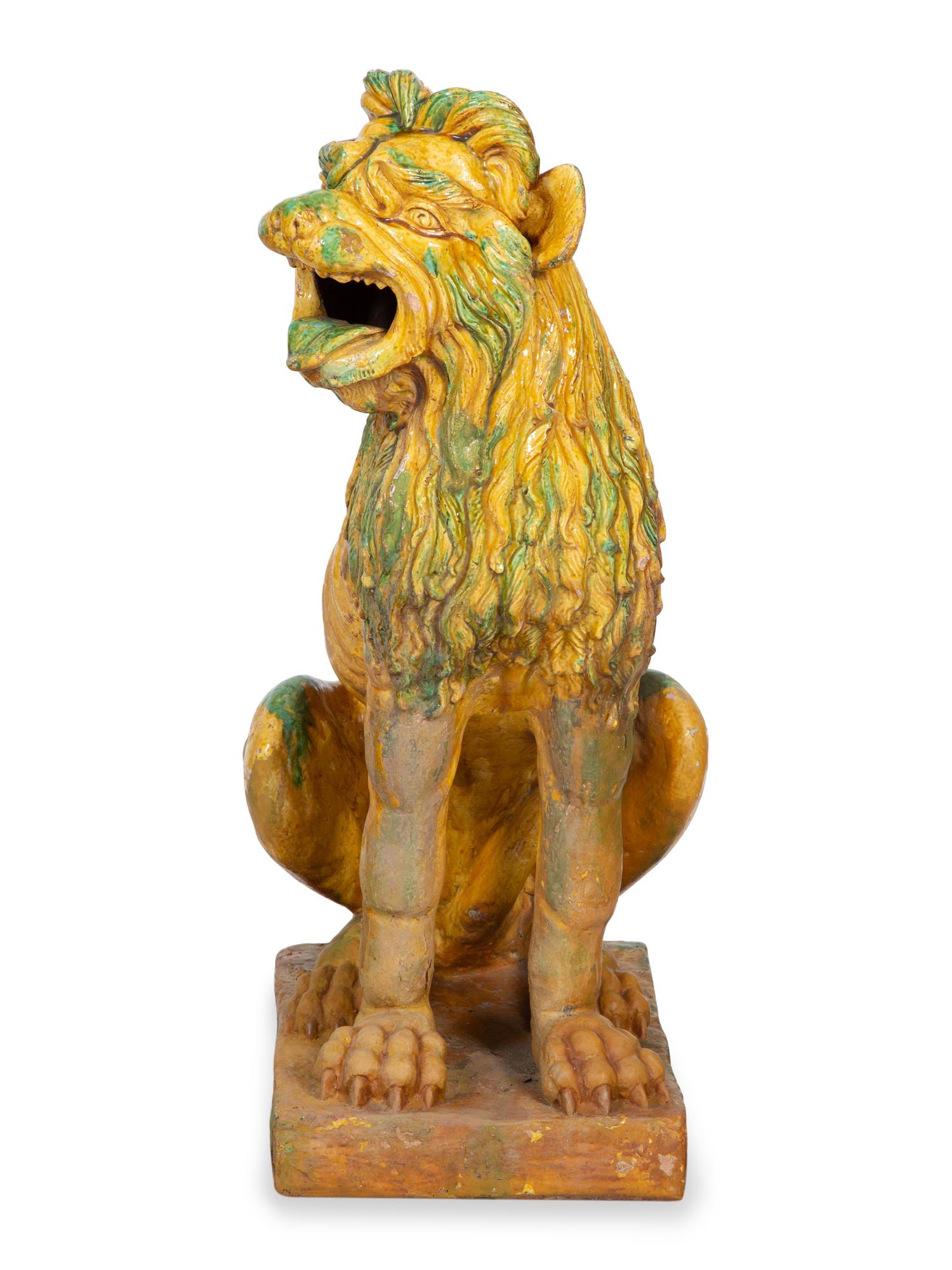 A Pair of Italian Yellow and Green Glazed Ceramic Figures of Seated Lions
