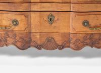 A Louis XV Provincial Carved Fruitwood Serpentine and Paneled-Top Bombé Commode
