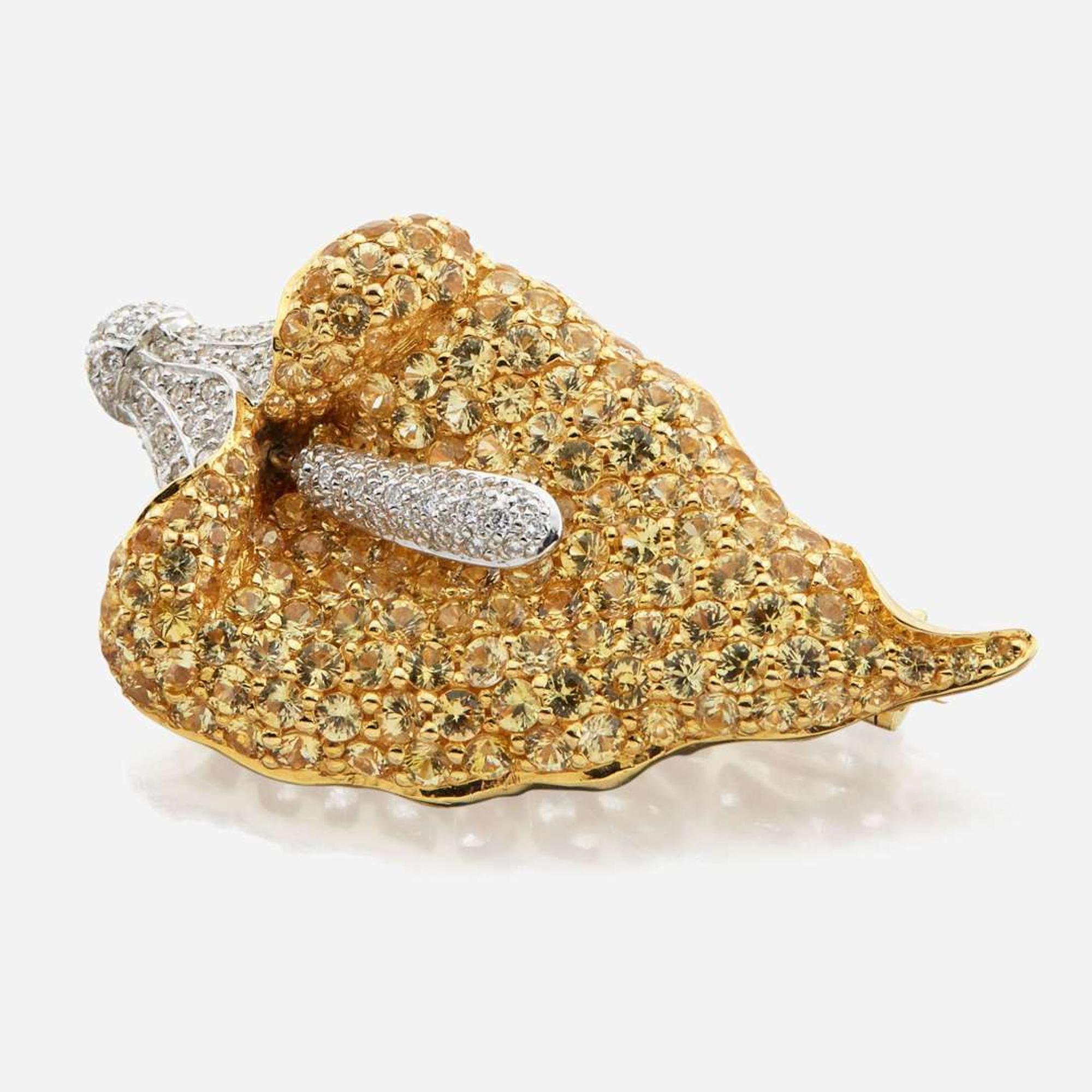 A diamond, sapphires, and white gold brooch