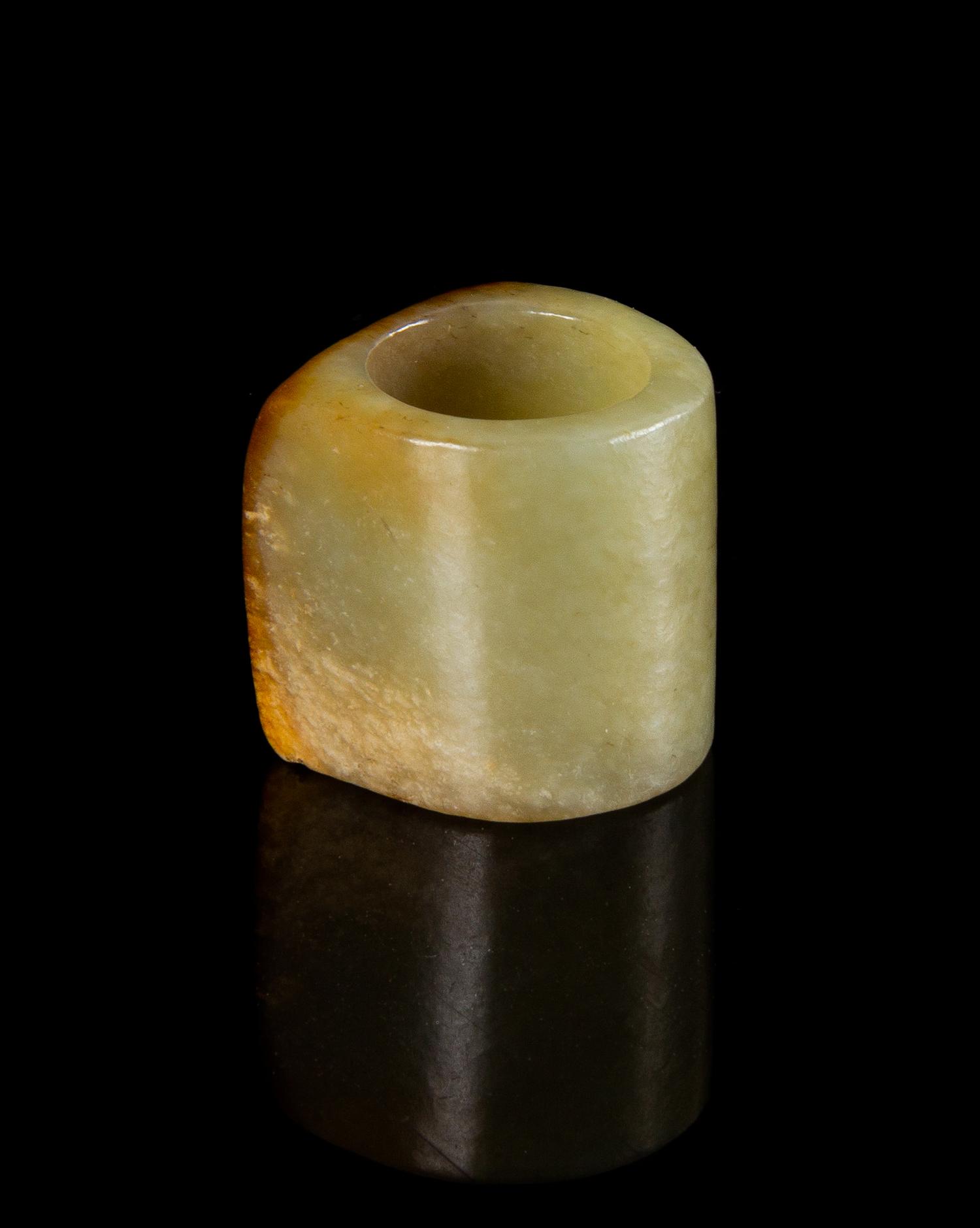 A Celadon and Russet Jade Archer's Ring Length 1 1/8 inches. — QING DYNASTY (1644-1911)