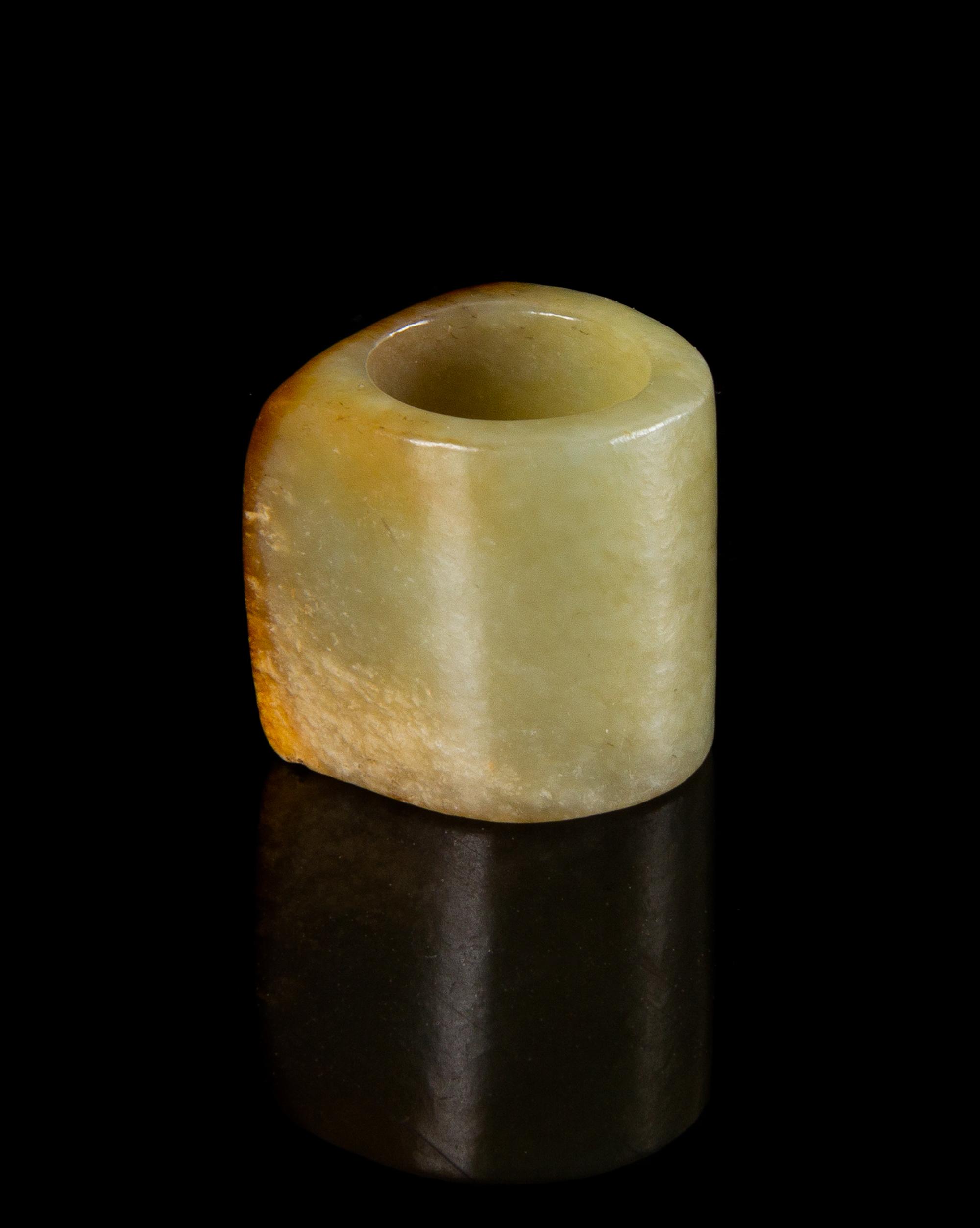 A Celadon and Russet Jade Archer's Ring Length 1 1/8 inches. — QING DYNASTY (1644-1911)