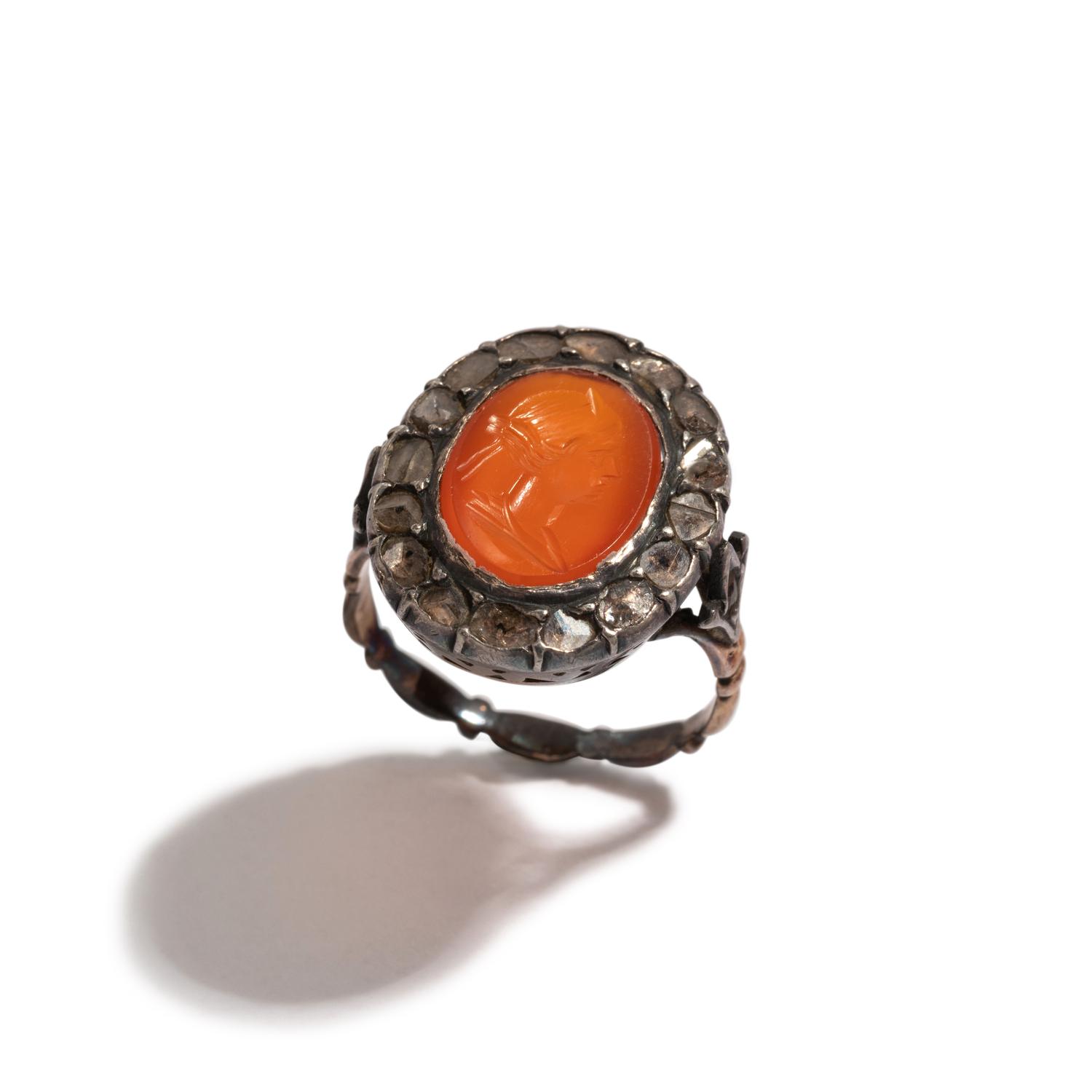 A Neoclassical Silver and Carnelian Finger Ring with a Portrait Head of a Woman Inside a Halo of Diamonds