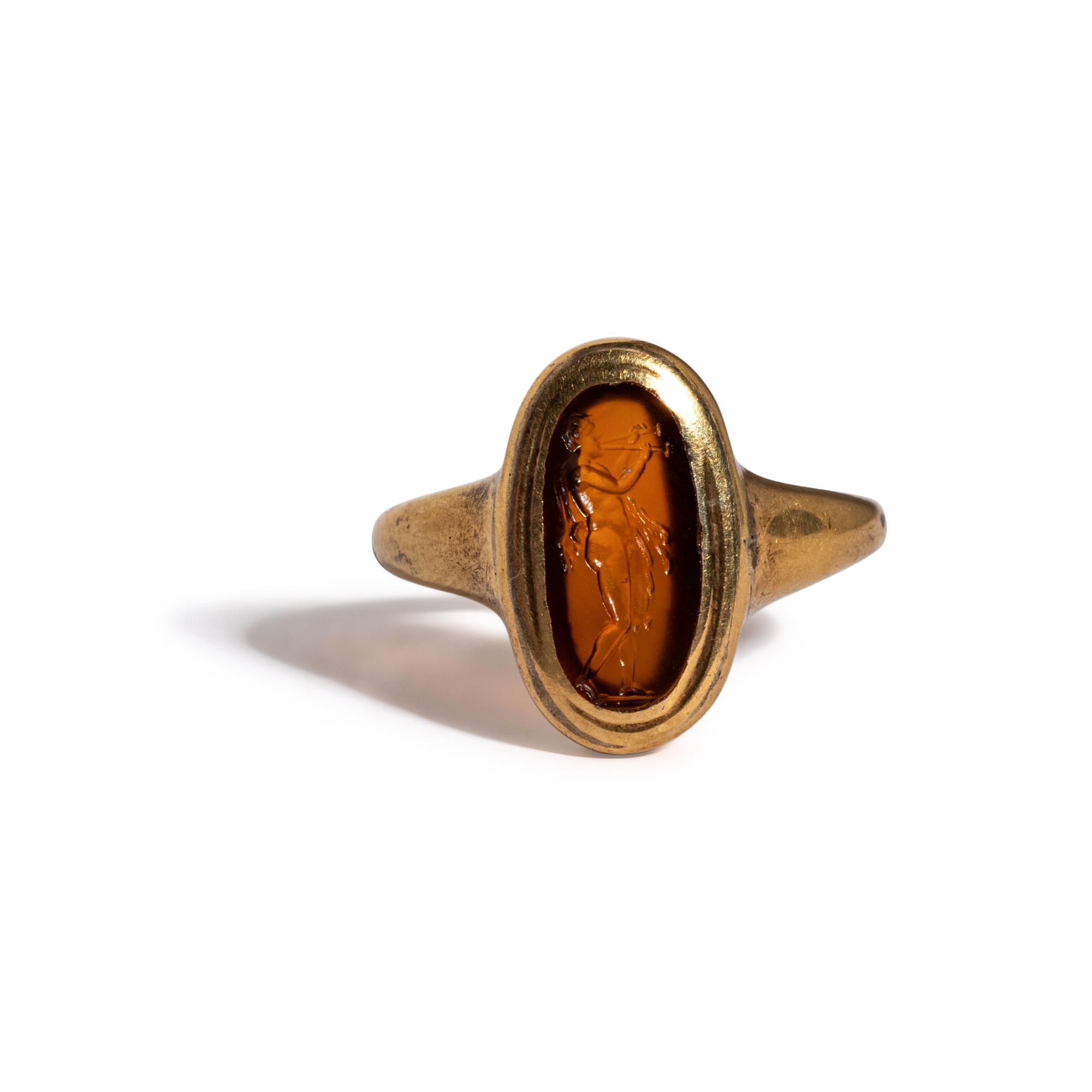 A Roman Carnelian Ring Stone with the God Silenus Playing an Aulos — Set in a gold ring